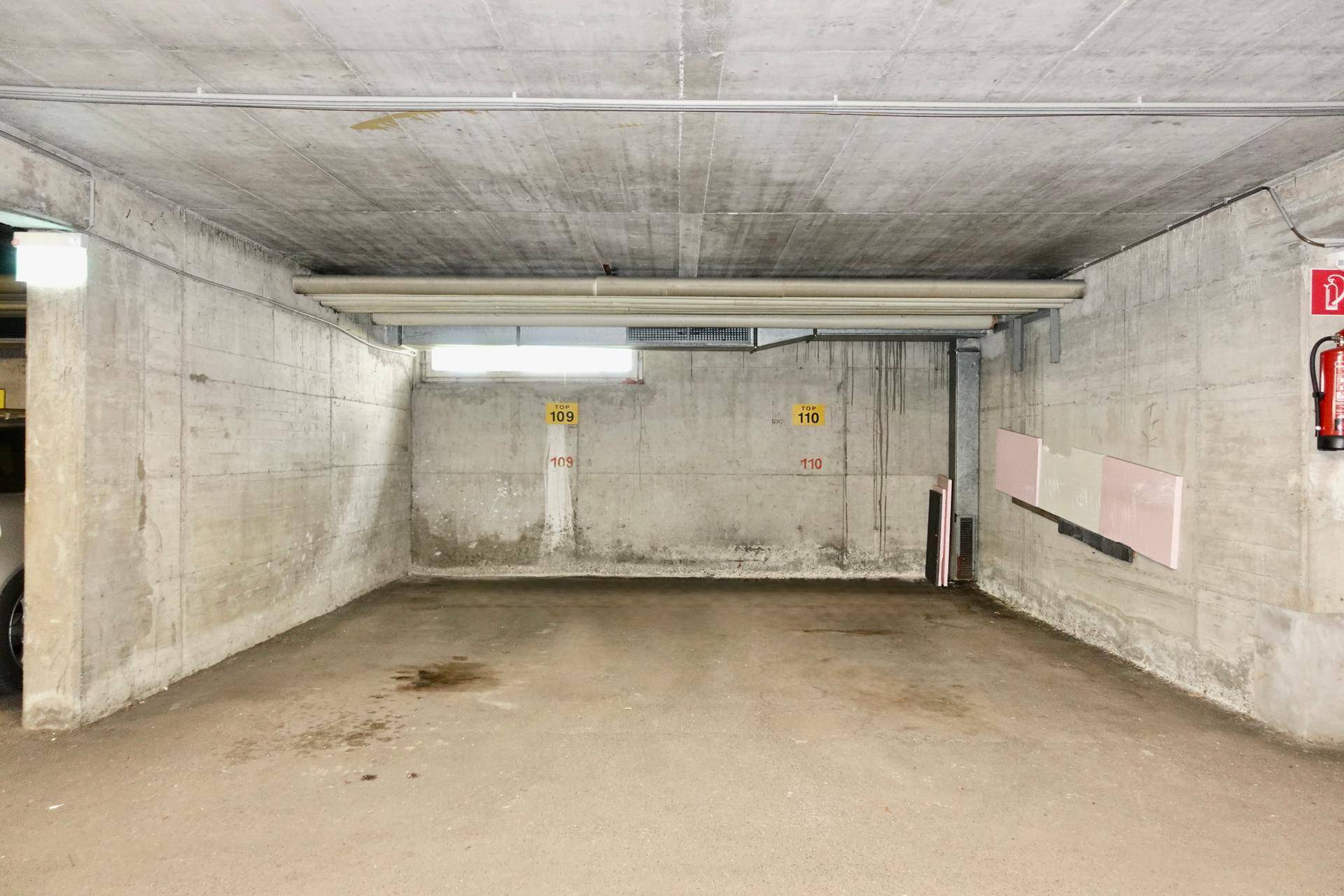 Leere Tiefgarage mit Betonwänden und -decke, bereit für Fahrzeuge.