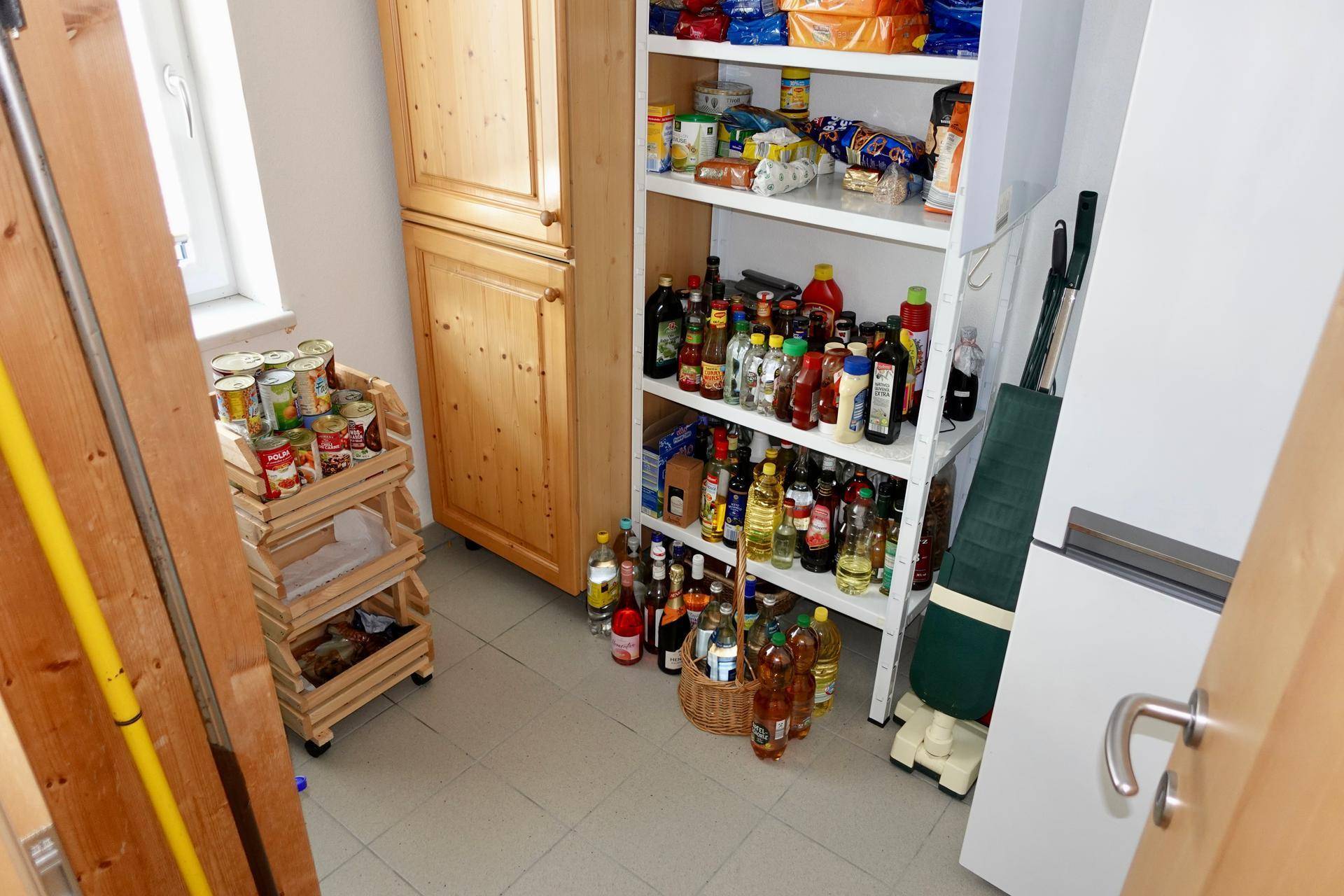 Gut gefüllte Speisekammer mit Regalen und Vorräten.