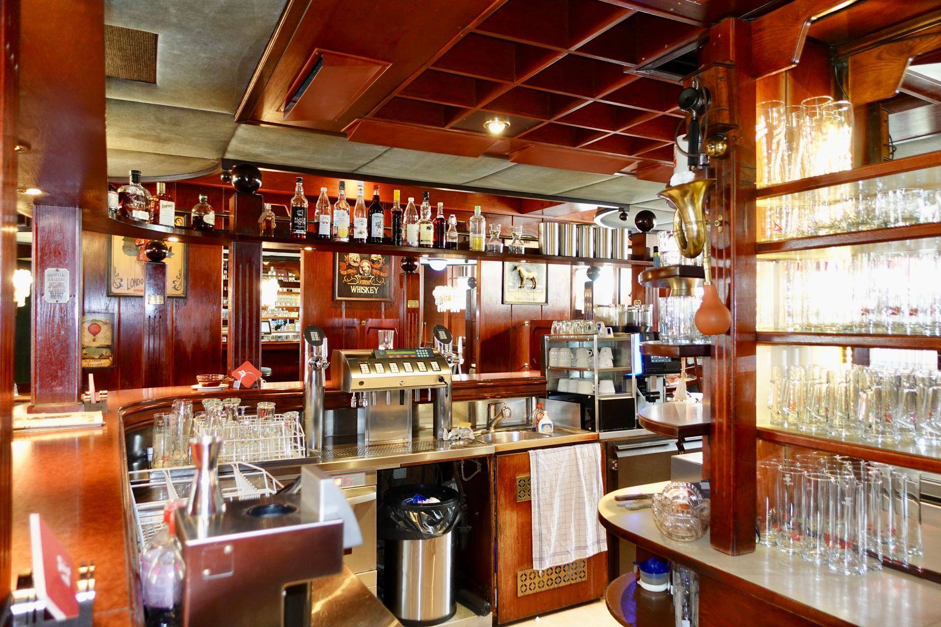 Detailansicht der Bar mit einer Vielzahl von Flaschen, Gläsern und Zapfanlagen, bereit für den Service.