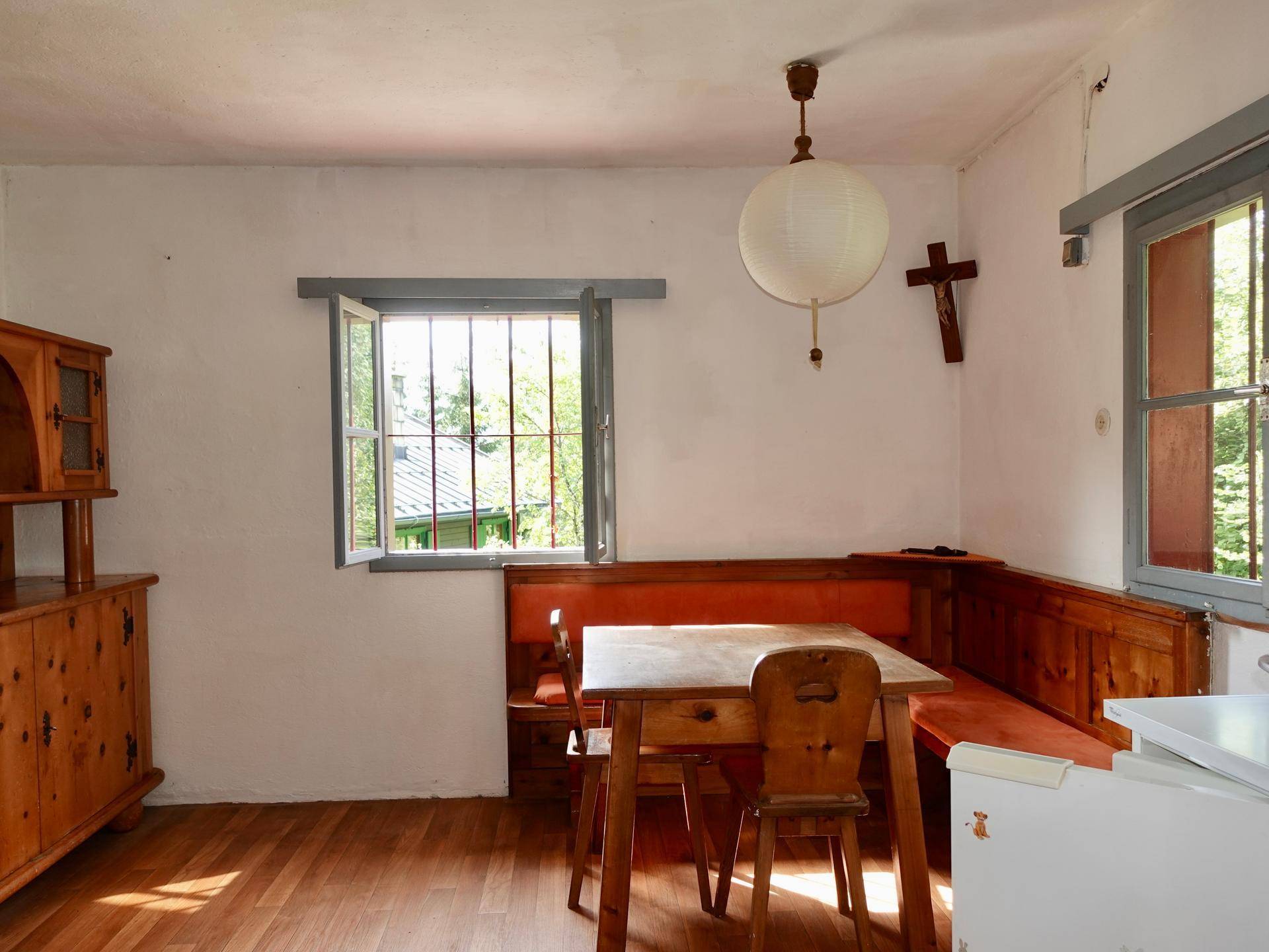 Rustikaler Essbereich mit Holztisch, Eckbank und traditionellem Holzschrank.