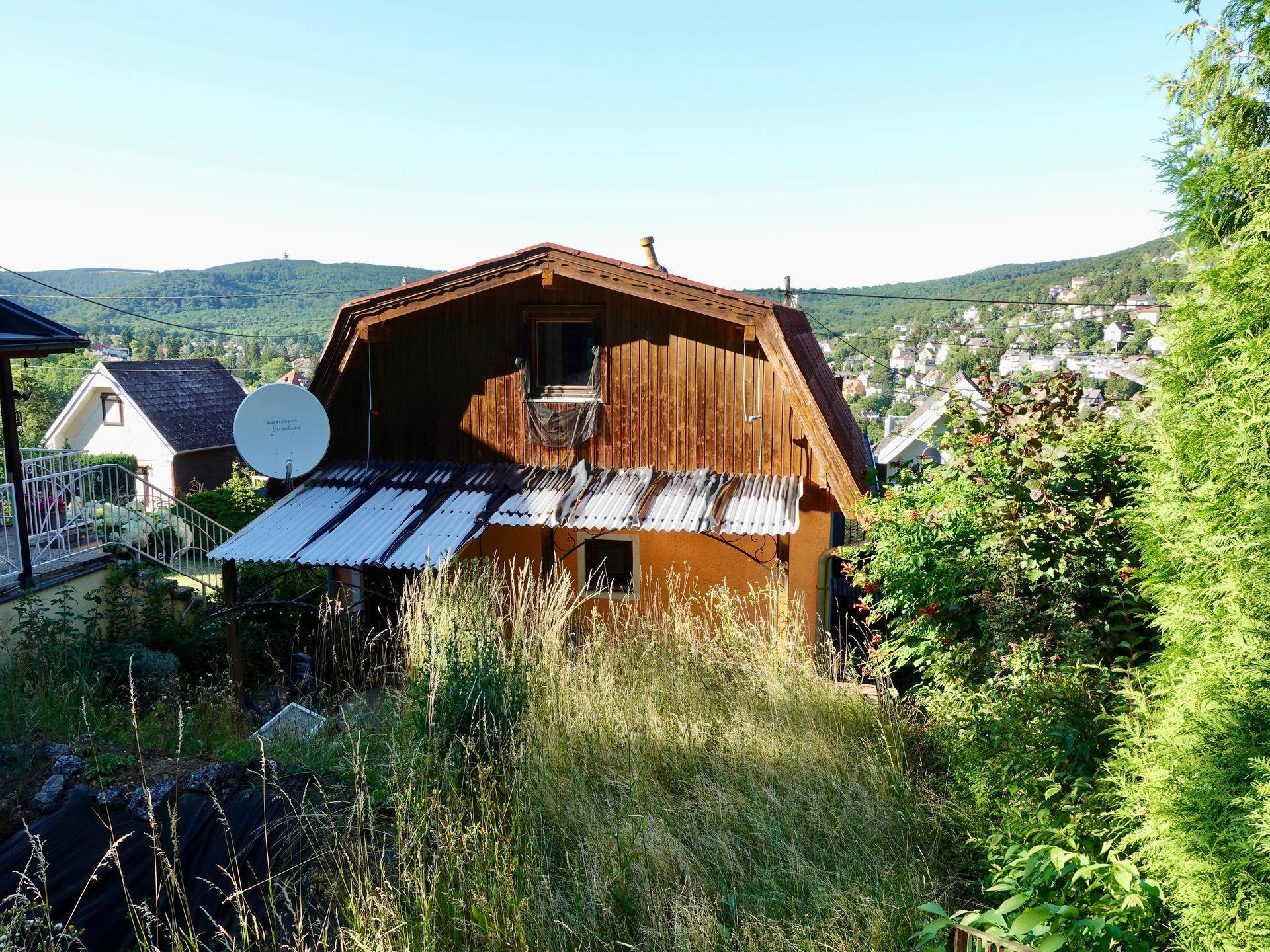 Rustikales Holzhaus mit Satteldach und Blick auf die umliegende Landschaft.