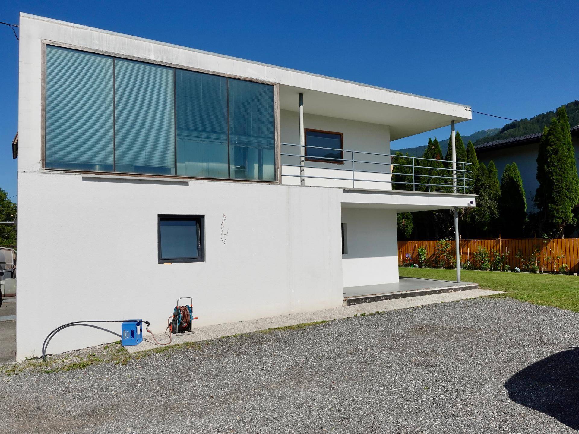Moderne Architektur des Hauses mit großer Glasfassade und Balkonen.