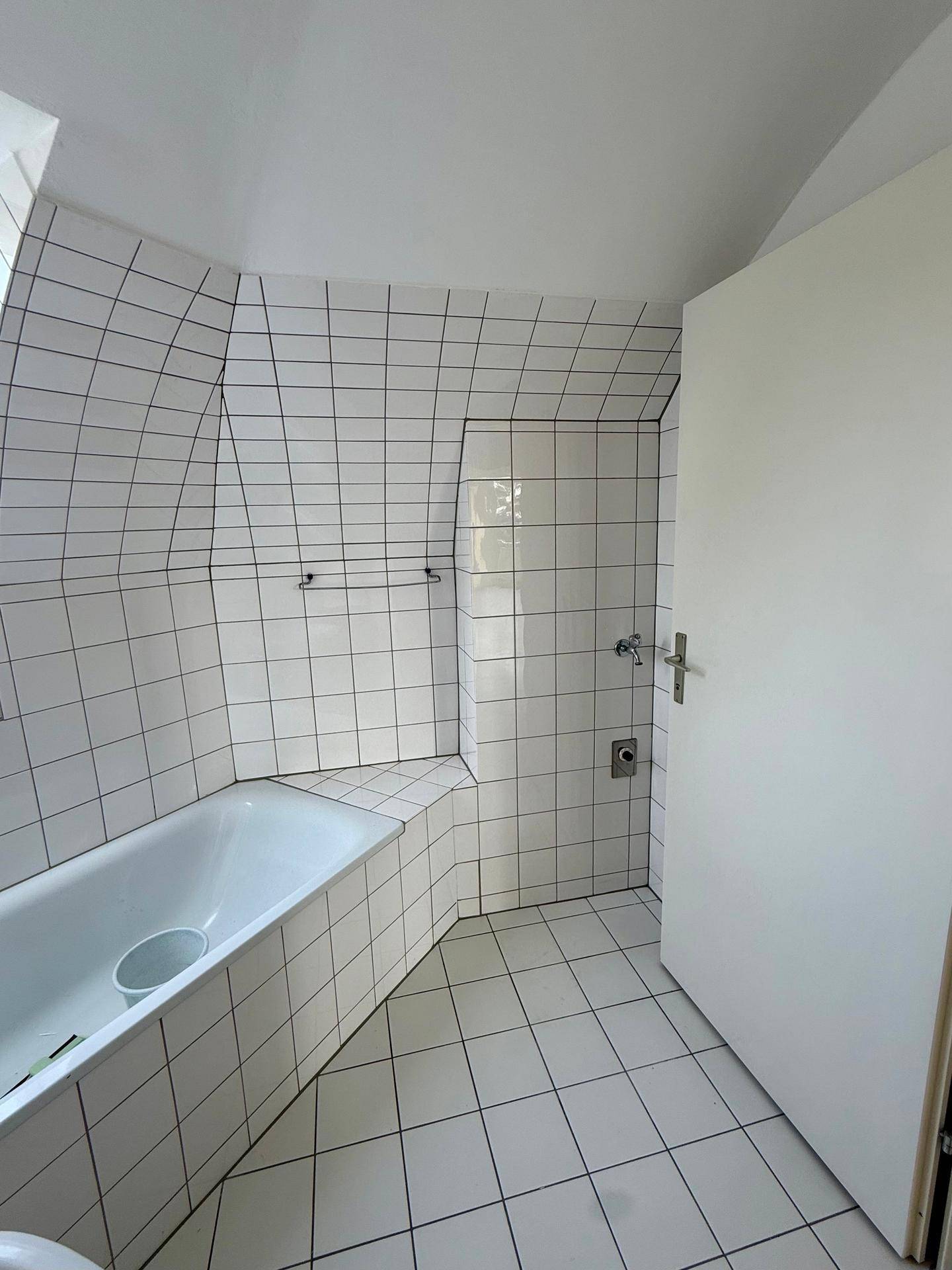 Badezimmer mit eingebauter Badewanne und weißen Fliesen, bietet eine saubere Optik.