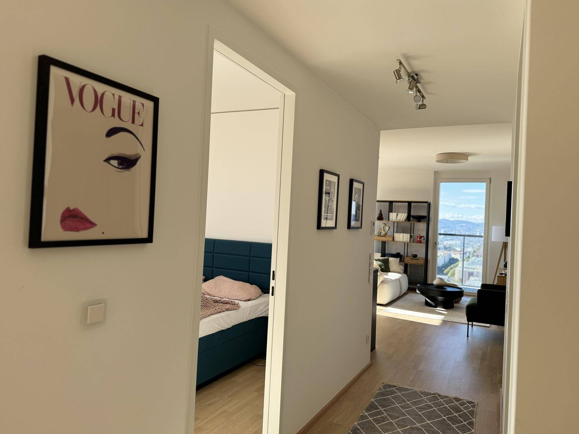Heller Flur mit modernem Kunstwerk, Holzboden und Blick in die angrenzenden Räume.