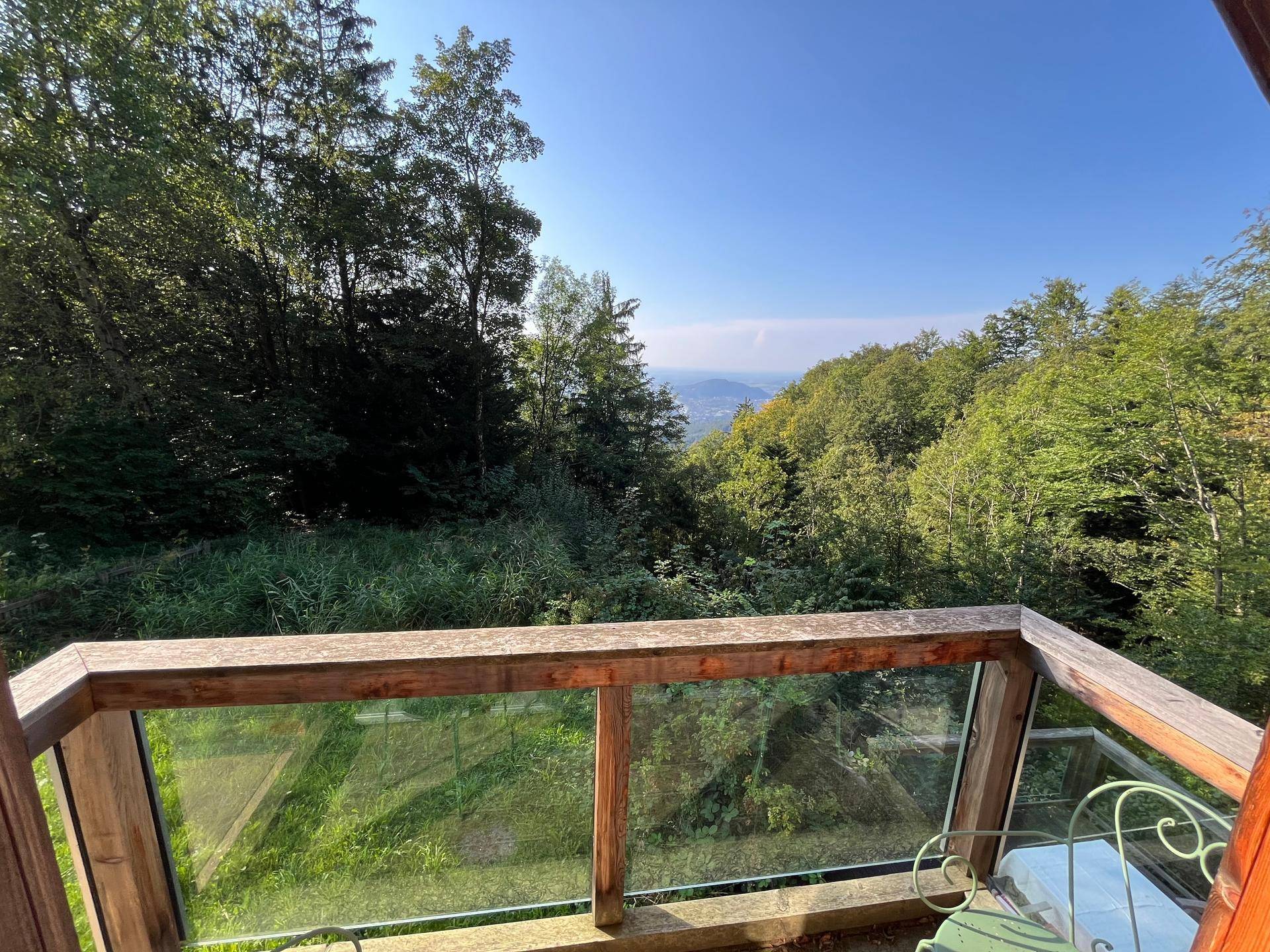Balkon mit Glasgeländer bietet einen atemberaubenden Blick über die grüne Landschaft.