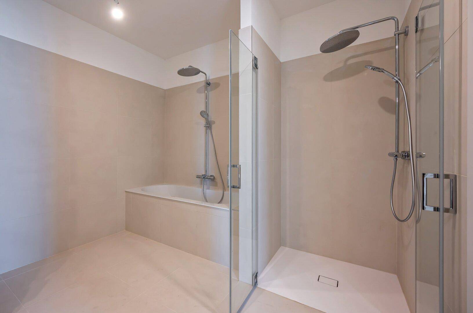 Modernes Badezimmer mit Badewanne, separater Dusche und beigefarbenen Fliesen.
