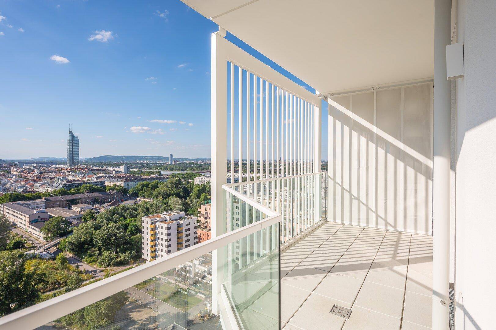 Eckbalkon mit moderner Brüstung und Panoramablick auf die Stadt und die grüne Umgebung.