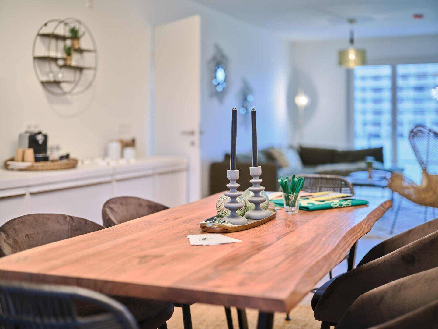 Essbereich mit rustikalem Holztisch und modernen Stühlen, offen zum Wohnzimmer.