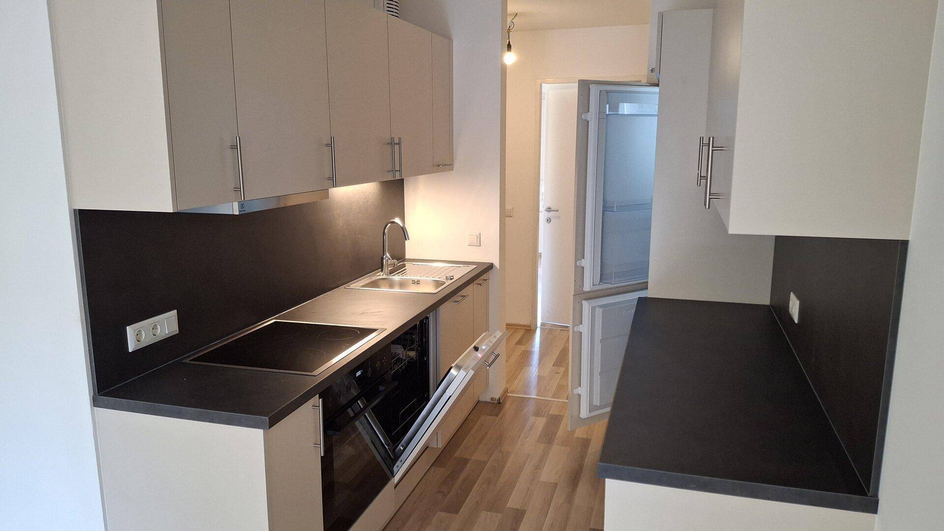 Gut ausgestattete Küche mit modernen Geräten und ausreichend Stauraum, in hellem Design.