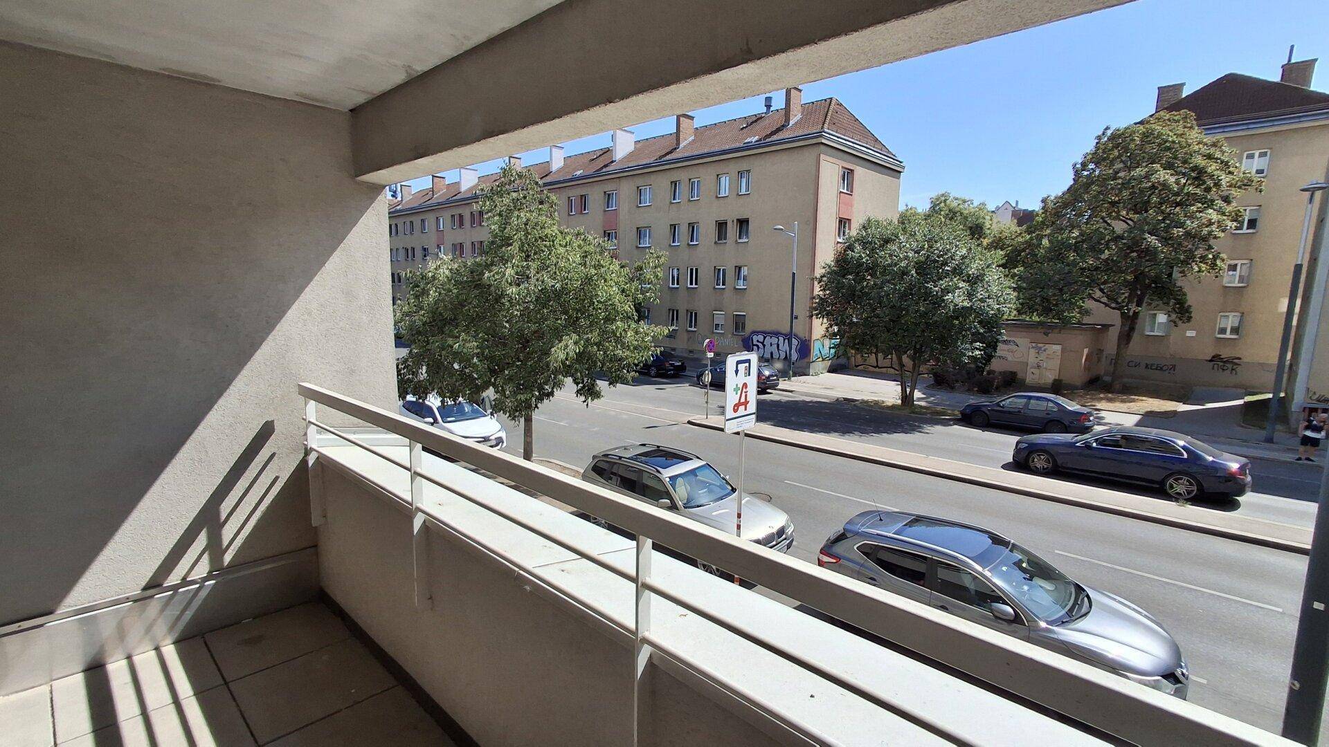 Heller Balkon mit Blick auf die Straße und die umliegenden Gebäude, ideal zum Entspannen.