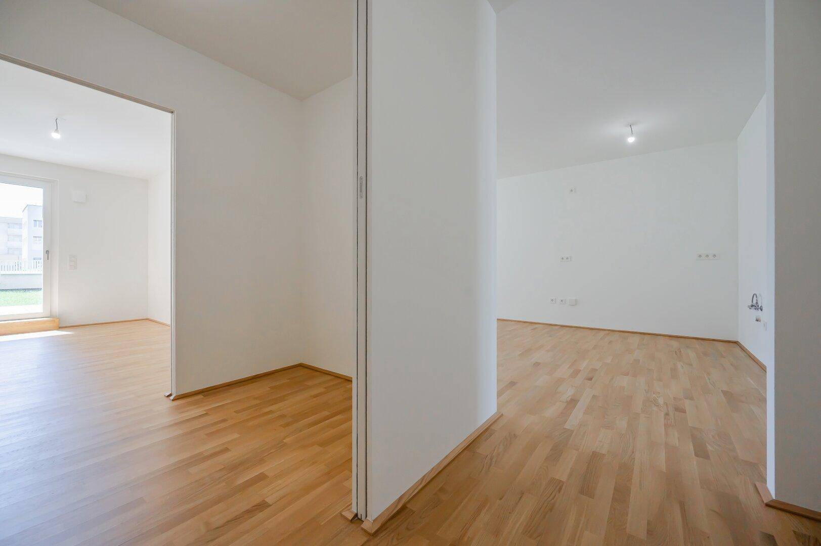 Heller Innenraum mit Parkettboden und offener Gestaltung, ideal für flexible Nutzung.