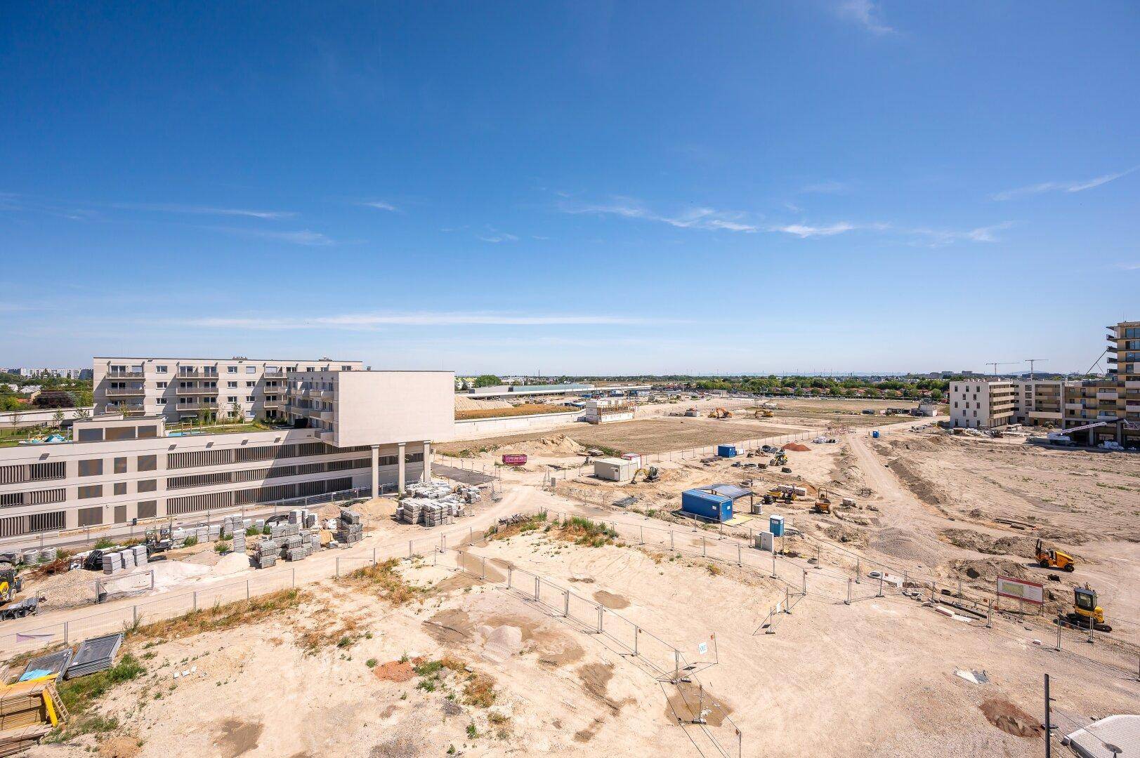 Panoramablick über eine Baustelle mit zukünftigen Wohngebäuden und weitem Horizont.