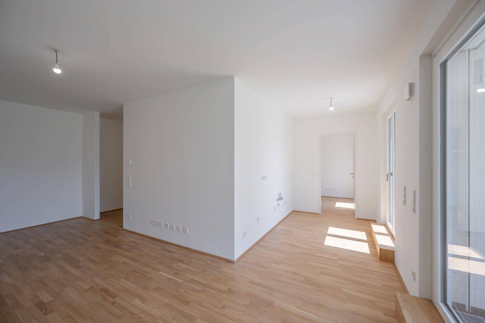 Geräumiger, heller Wohnbereich mit Parkettboden und viel Tageslicht.
