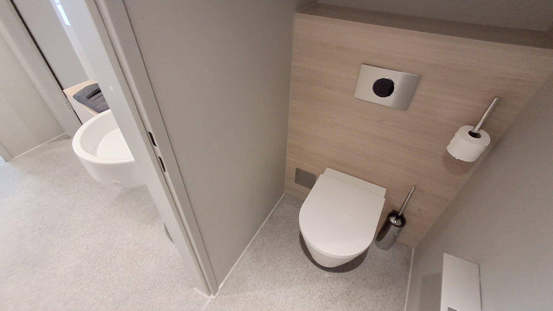 Detailansicht der wandhängenden Toilette in einem modernen Gäste-WC mit stilvoller Ausstattung.