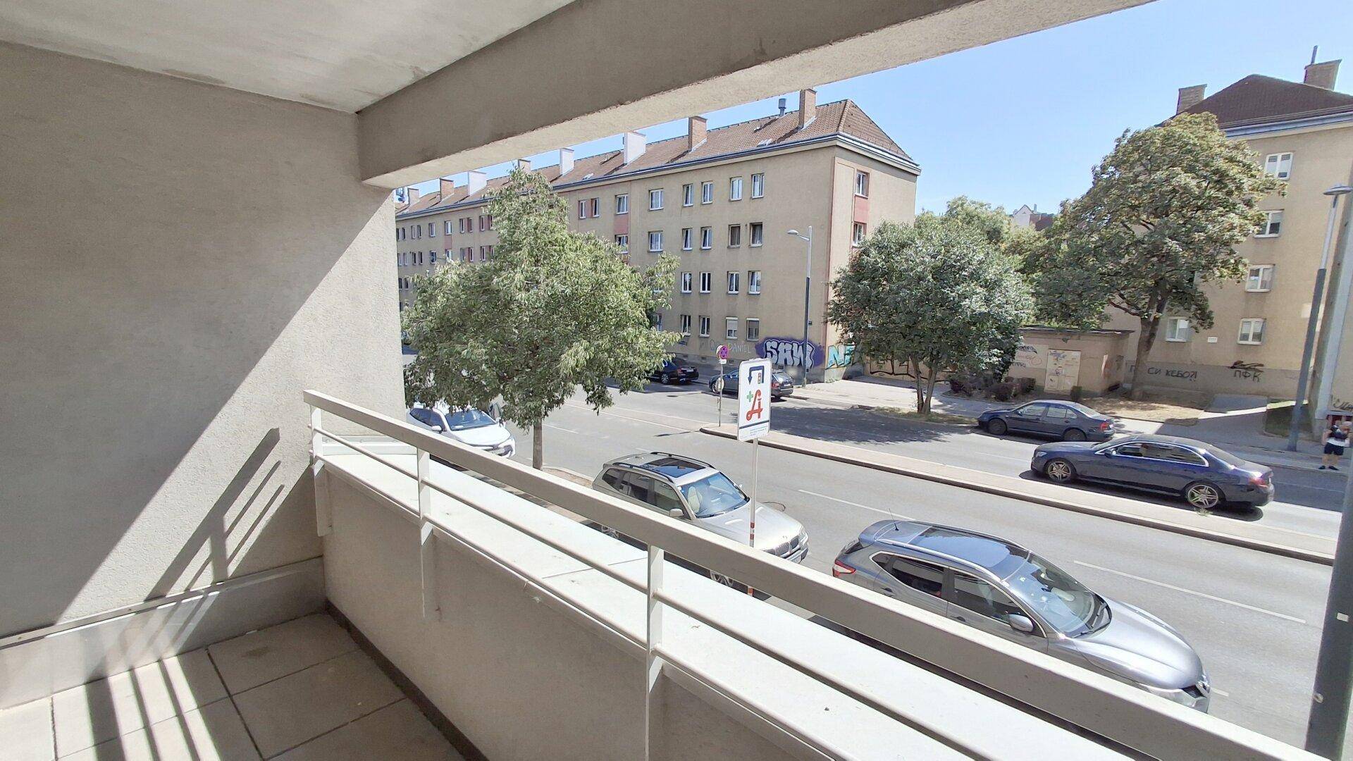 Balkon mit Blick auf die belebte Straße und die umliegenden Wohngebäude.