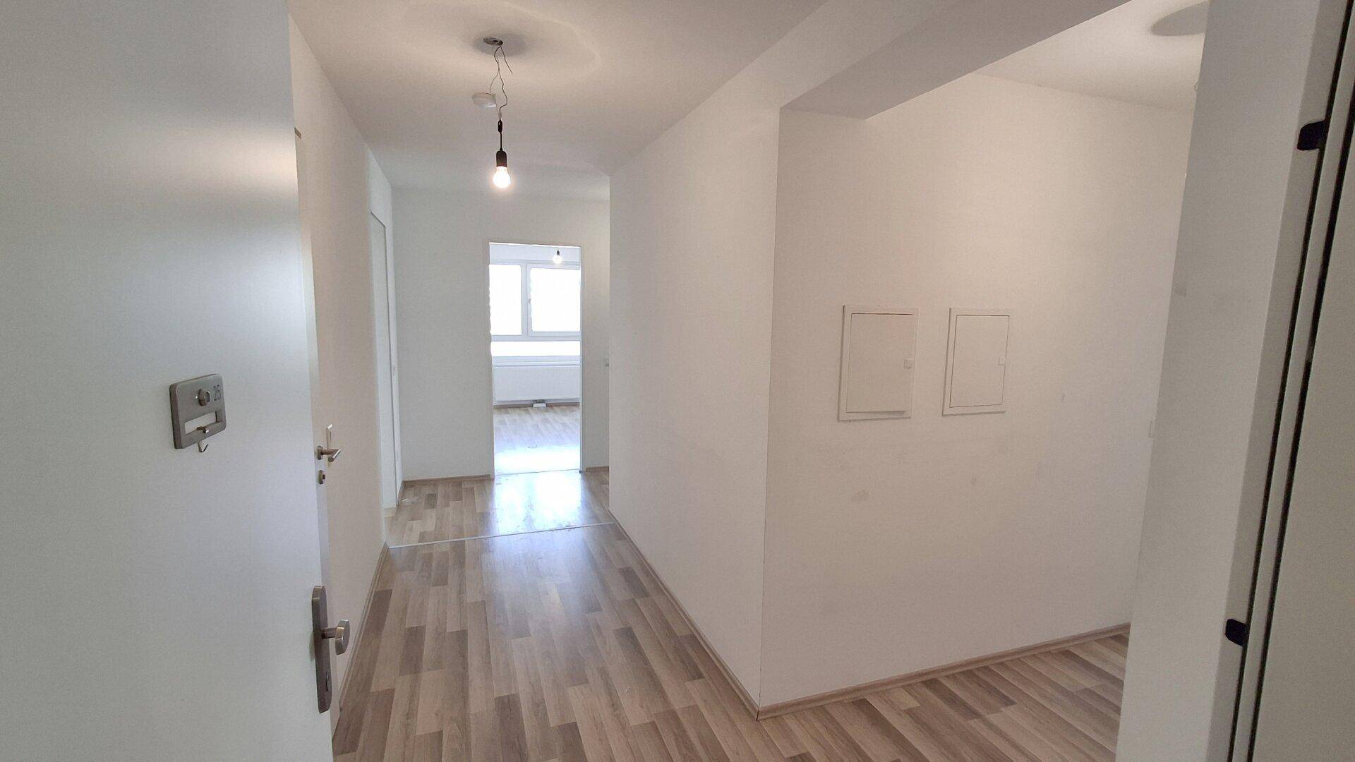 Heller Flur mit Laminatboden und Zugang zu weiteren Räumen in einem gepflegten Zustand.