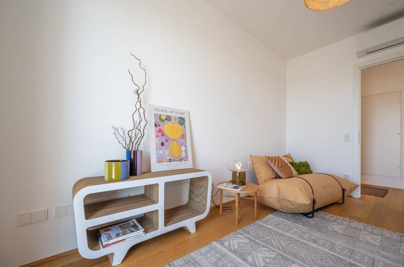 Gemütliches Arbeitszimmer mit Holzboden, stilvollen Möbeln und dekorativen Elementen.