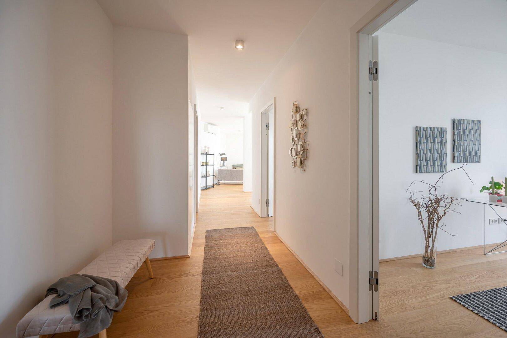 Heller Eingangsbereich mit Holzboden und Zugang zu den angrenzenden Räumen.