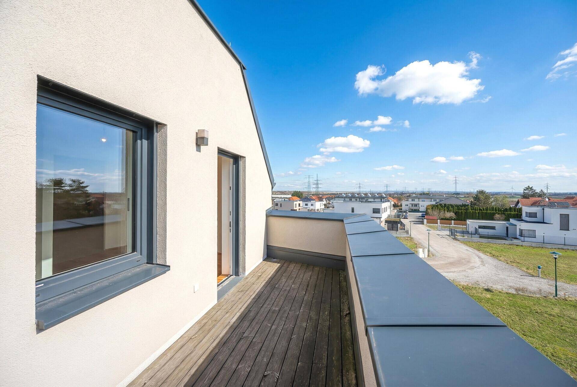 Dachterrasse mit Holzboden und Panoramablick auf die umliegende Landschaft.