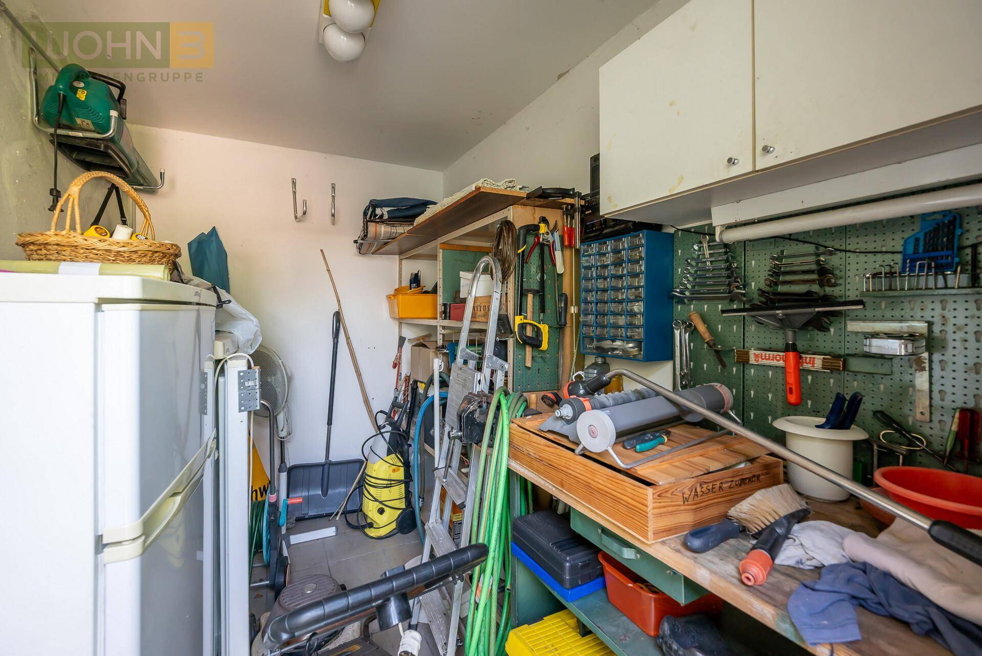 Abstellraum mit Regalen, Werkzeugen und einem Kühlschrank, ideal für Lagerzwecke.