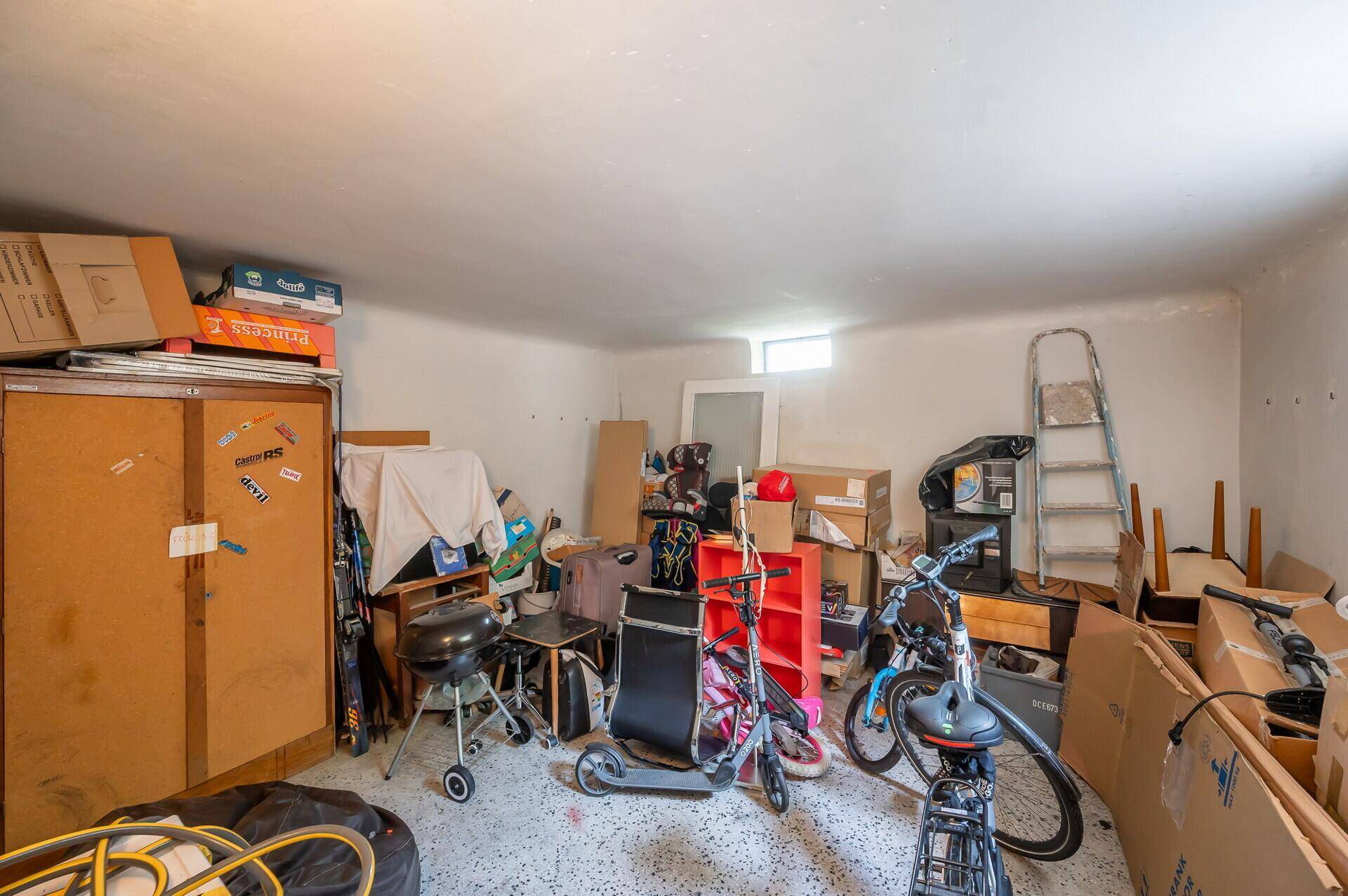 Geräumiger Abstellraum mit verschiedenen Gegenständen und einem kleinen Fenster.
