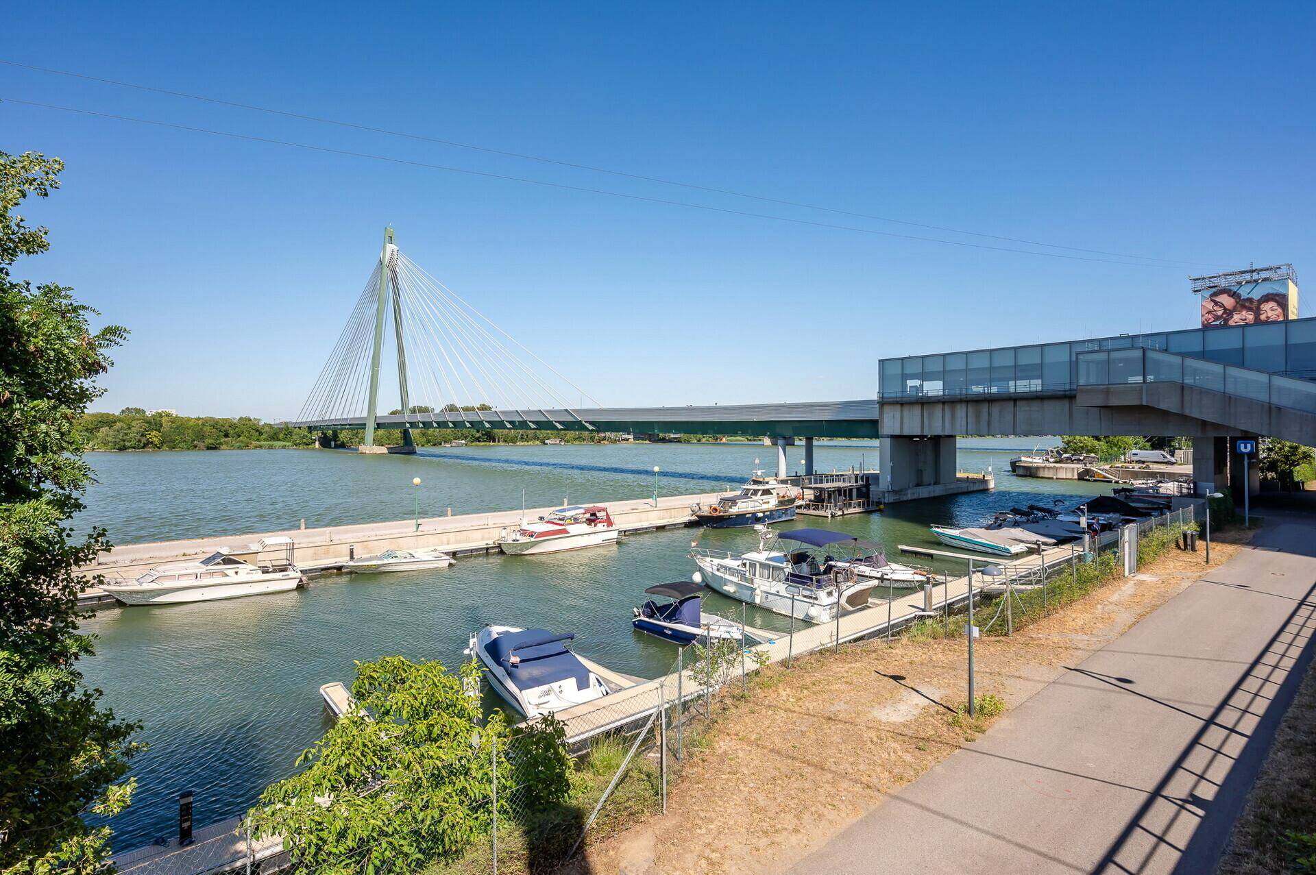 Marina mit zahlreichen Booten und einer modernen Brücke über das Wasser.