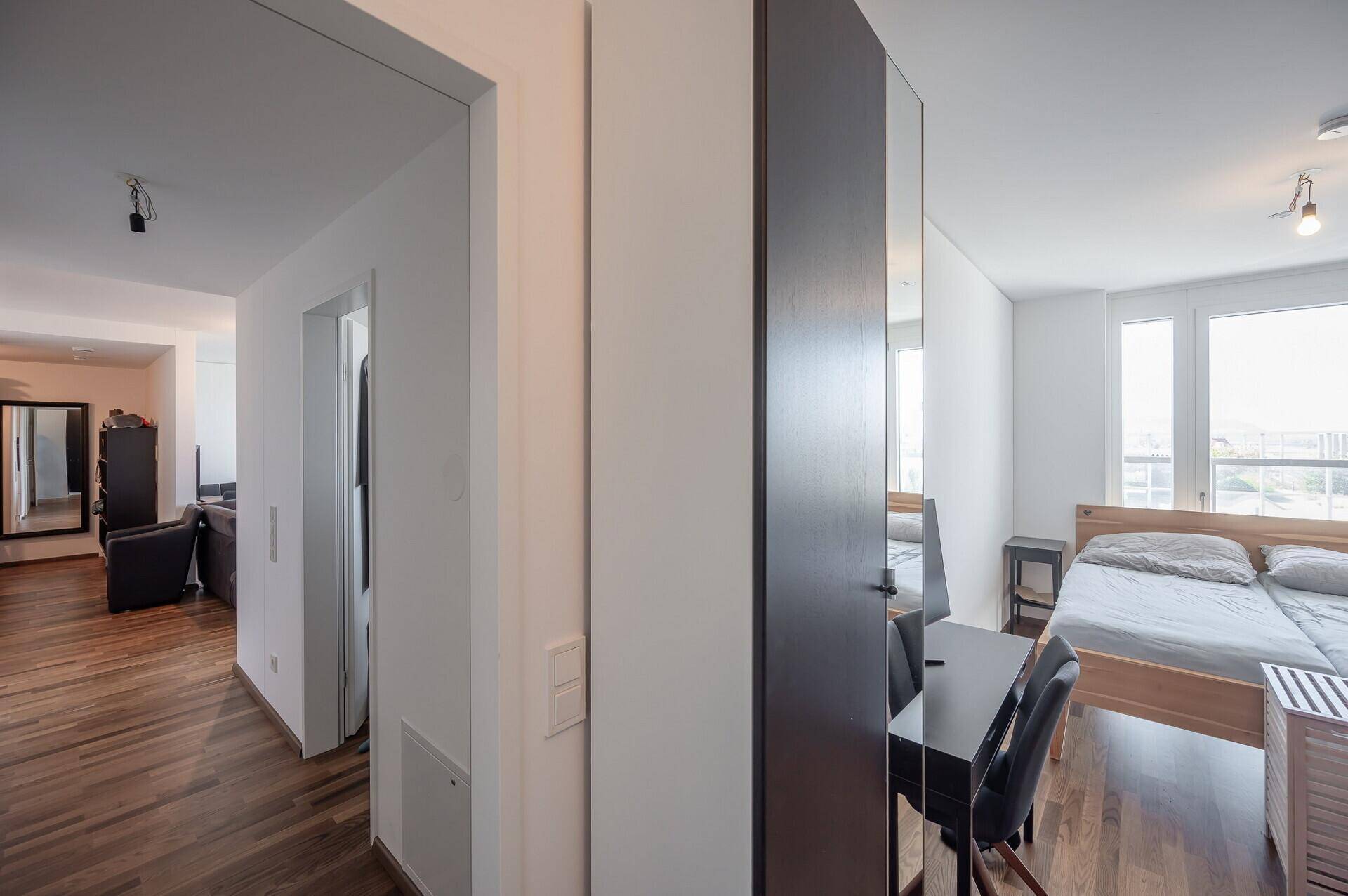 Heller Flur mit Holzboden, der zu den weiteren Räumen der Wohnung führt.
