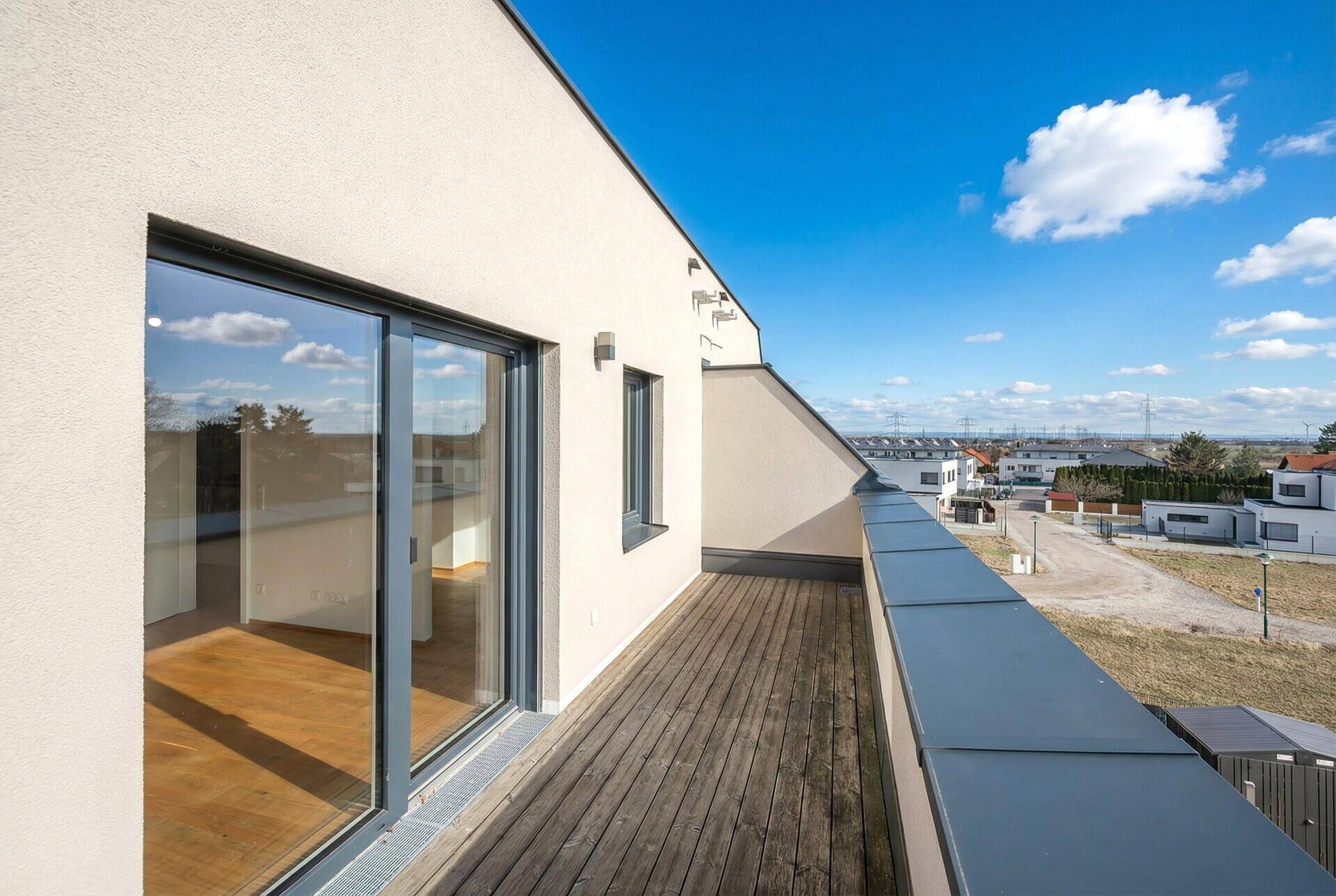 Geräumige Dachterrasse mit Holzboden und weitem Blick über die Umgebung.