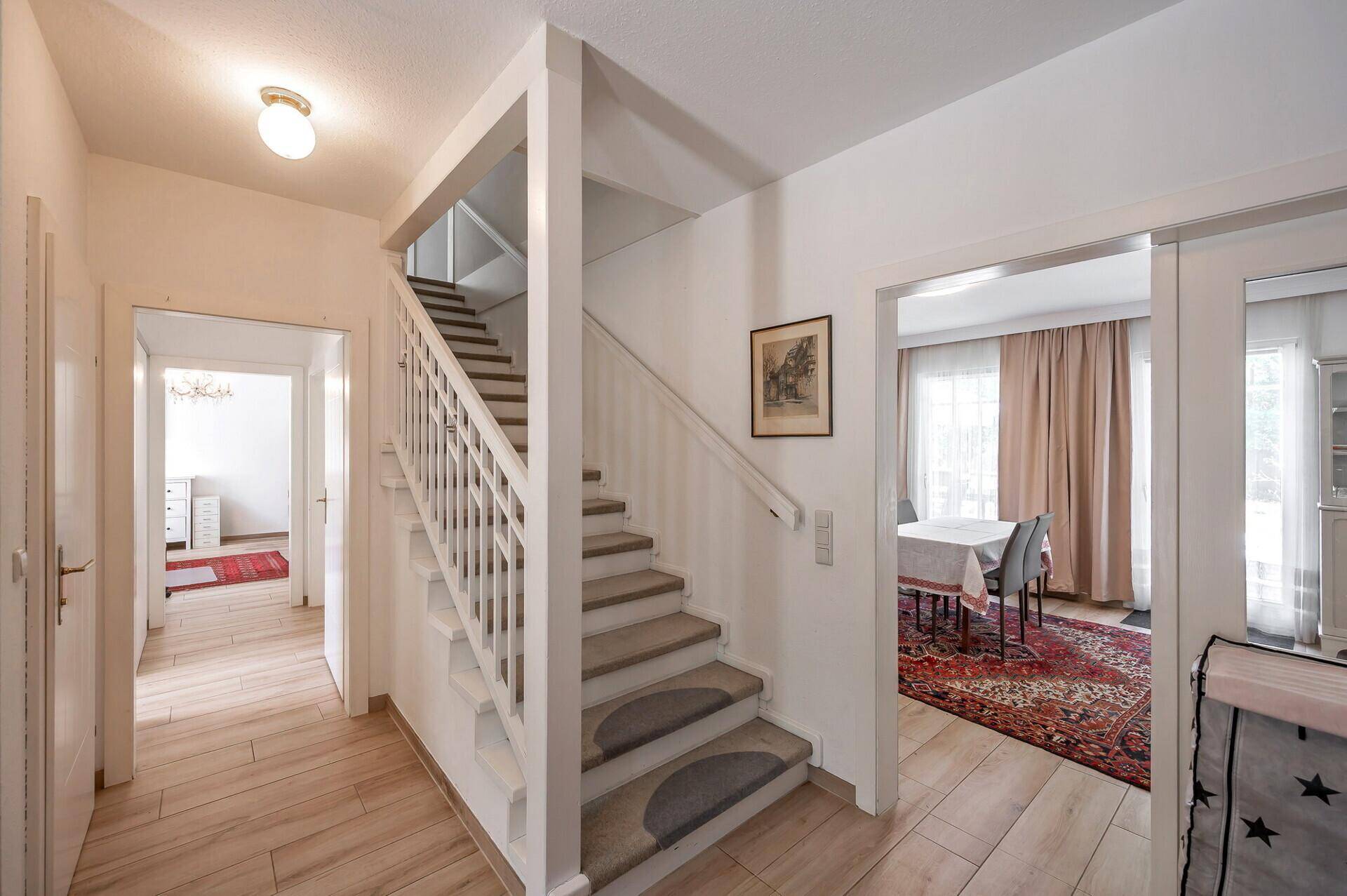 Geräumiger Flur mit Treppenaufgang und Zugang zu weiteren Zimmern im Haus.