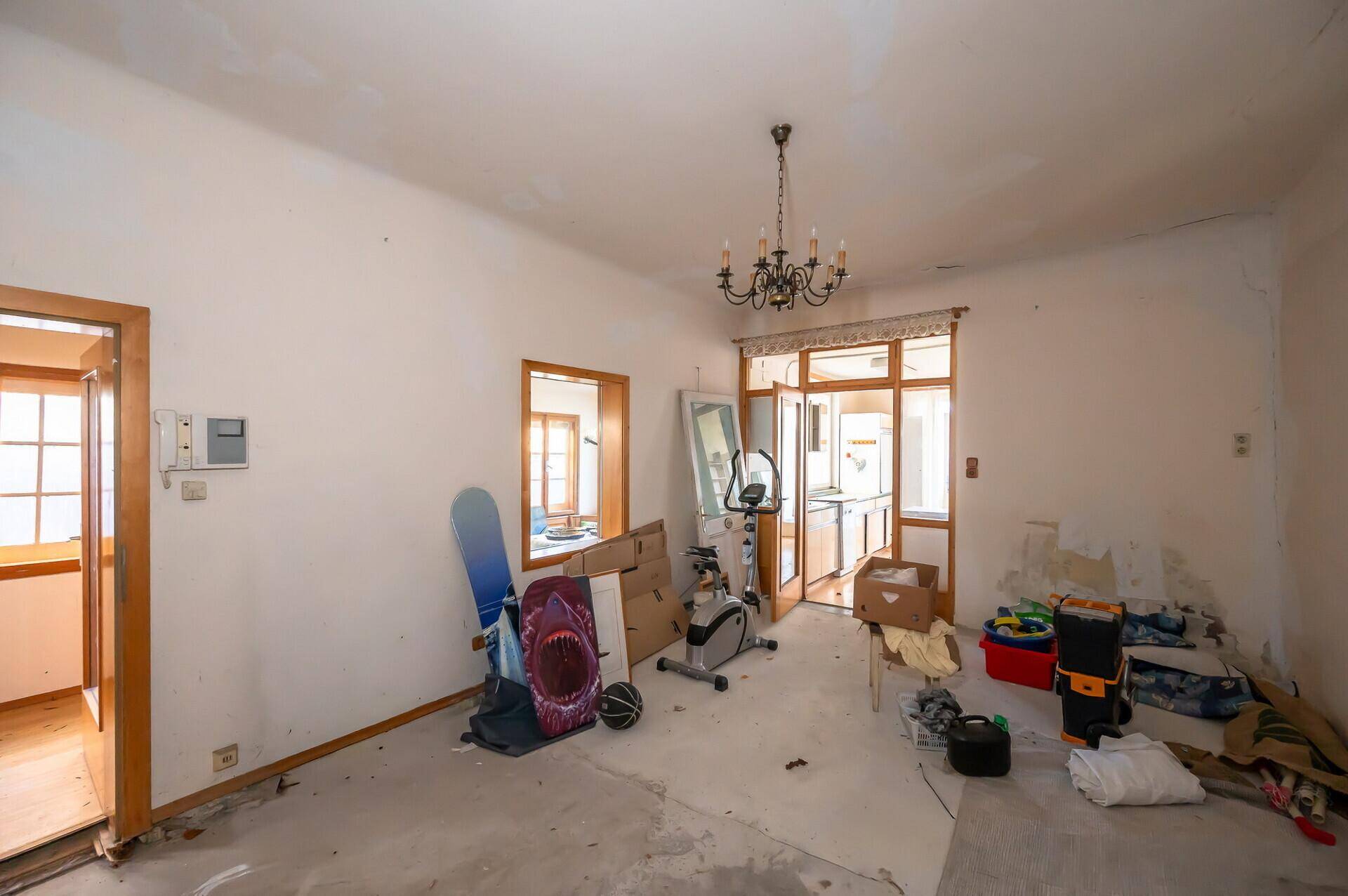 Zimmer mit unfertigem Boden und verschiedenen Gegenständen, bereit für die Renovierung.