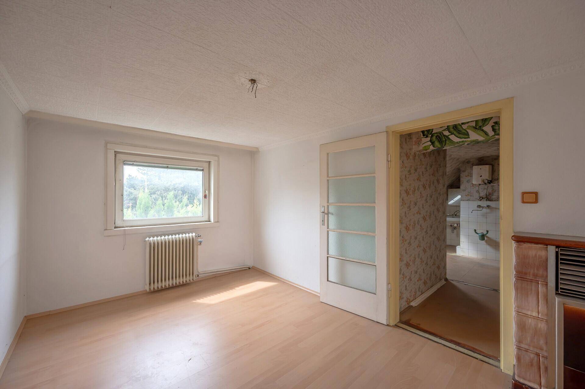 Helles Zimmer mit Holzboden und Kachelofen, ideal für gemütliche Stunden.