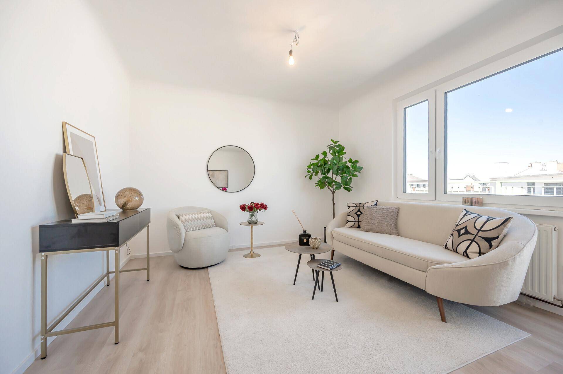 Gemütliches Wohnzimmer mit hellem Laminatboden und stilvoller Einrichtung.