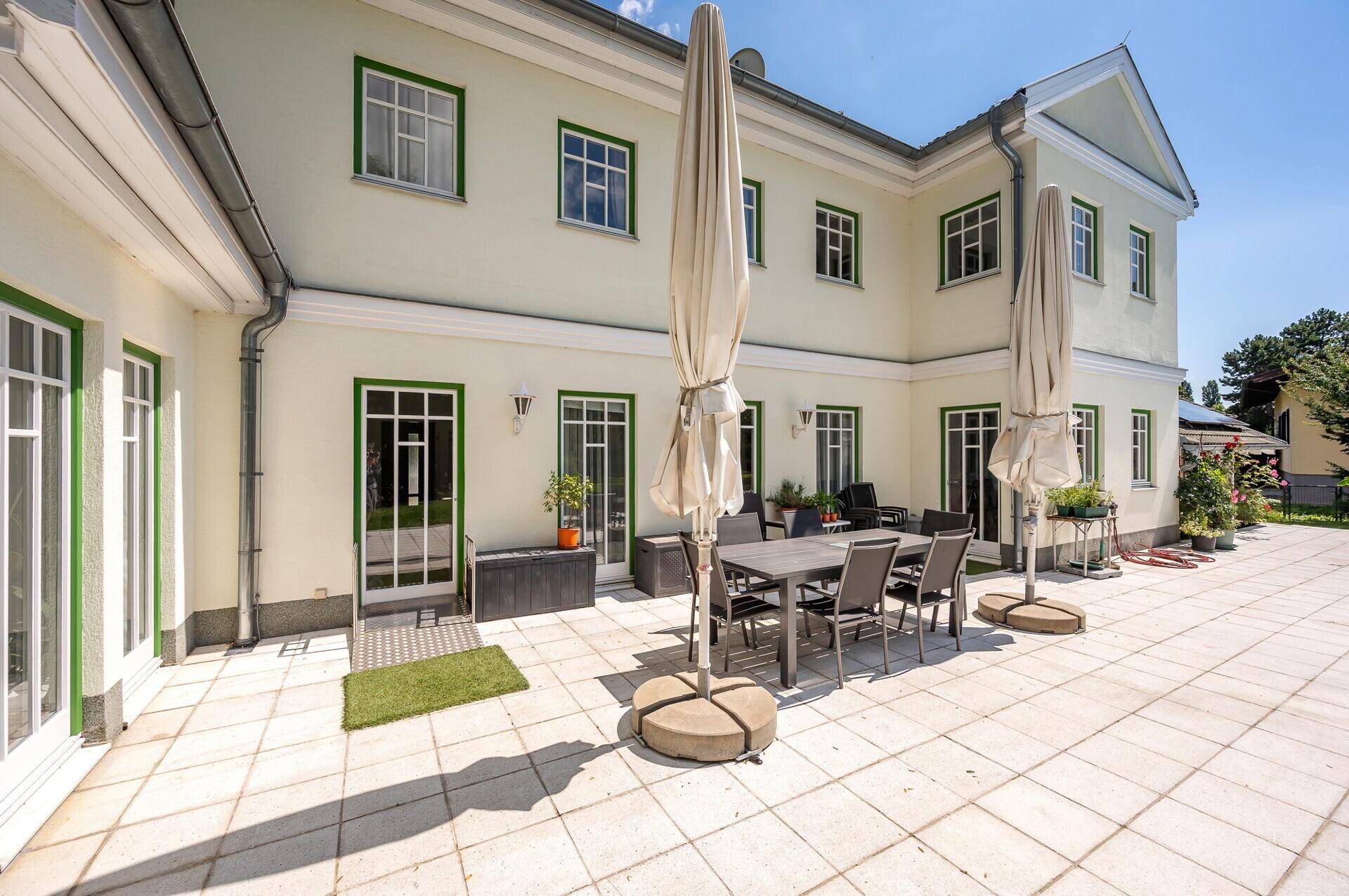 Geräumige Terrasse mit Gartenmöbeln und Zugang zum Haus.
