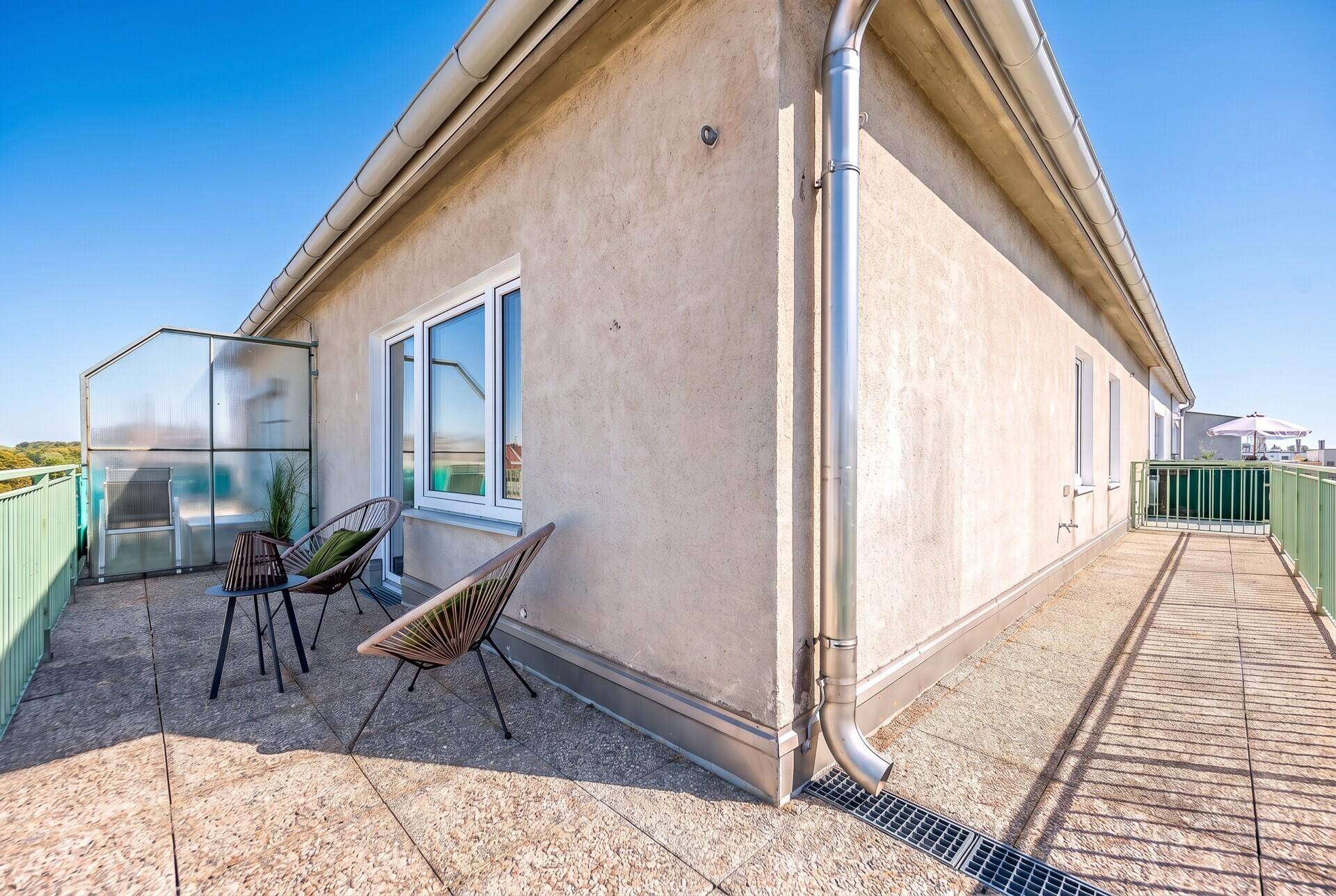 Langer Balkon mit Fliesenboden und Blick auf die umliegenden Gebäude.