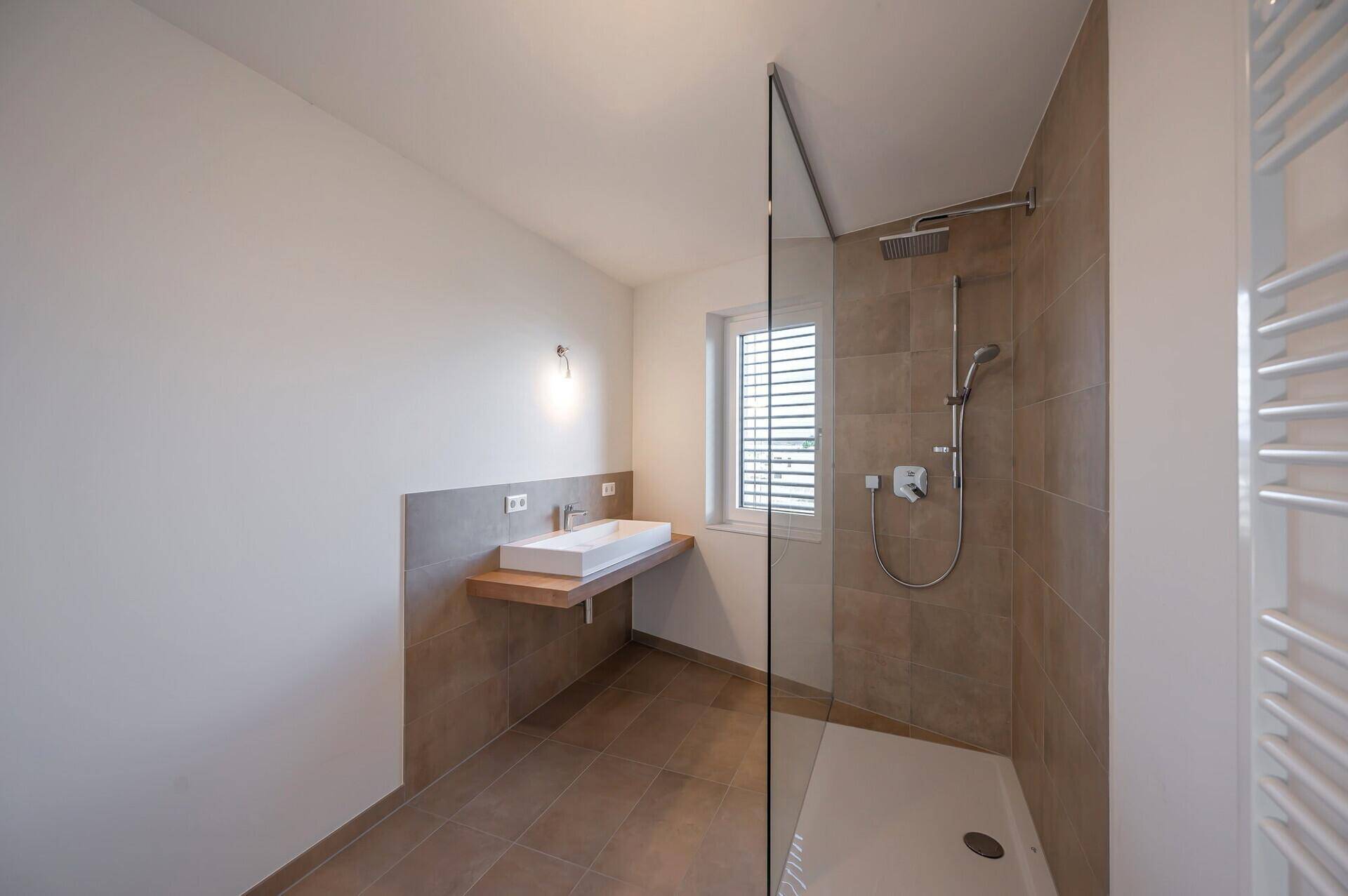 Modernes Badezimmer mit ebenerdiger Dusche, Einzelwaschbecken und Fenster.