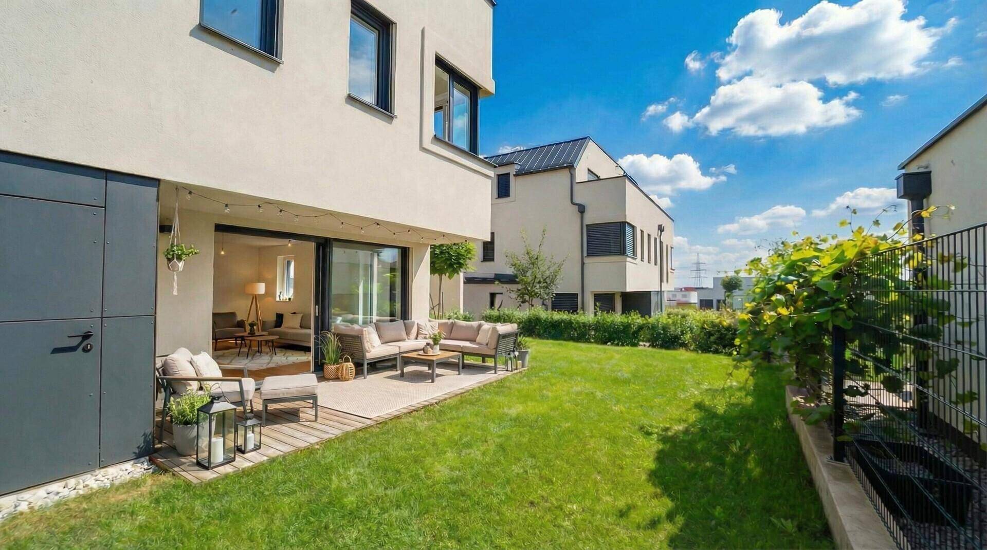 Moderne Doppelhaushälfte mit großer Terrasse, Garten und Blick auf die Nachbarschaft.