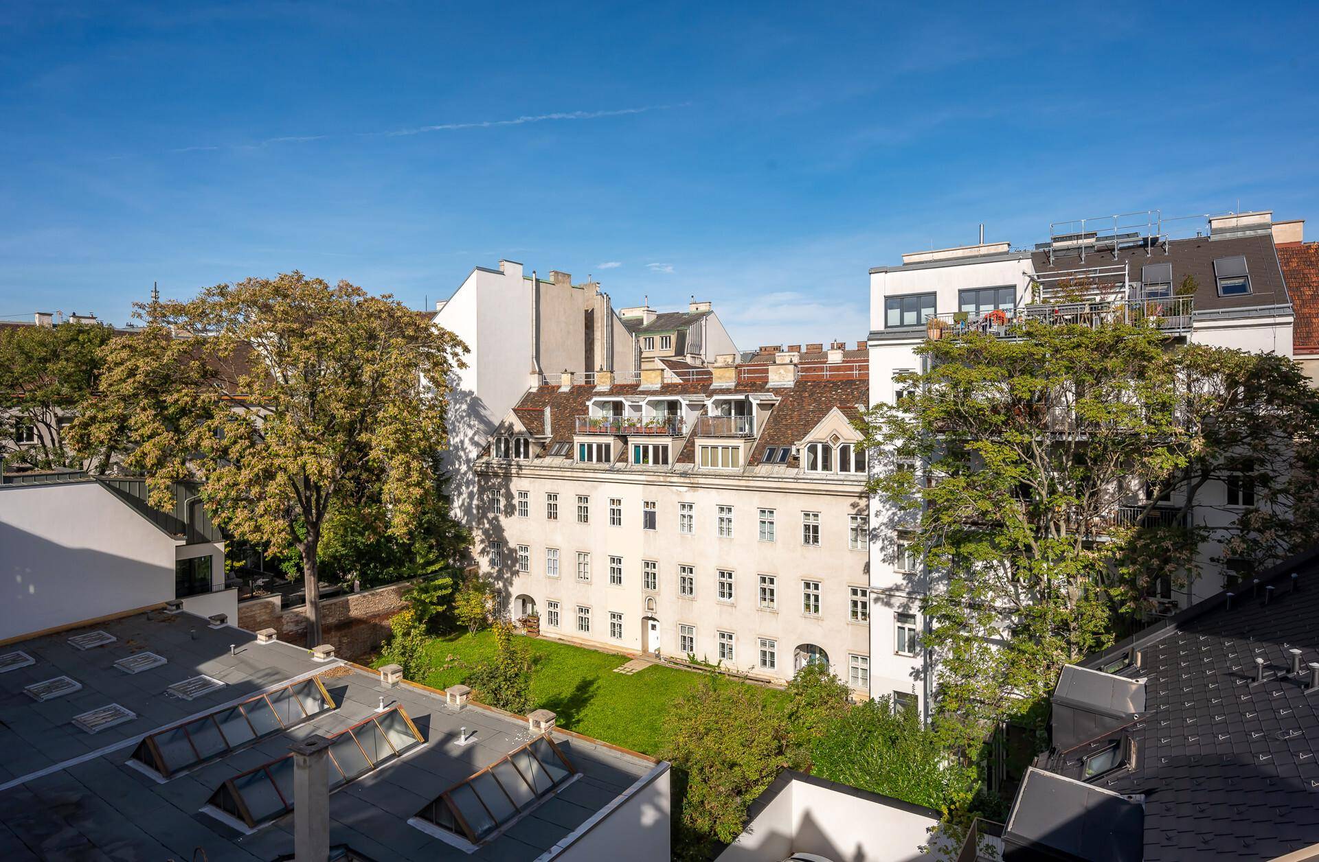 Panoramablick über die Stadt mit historischen Gebäuden und einem grünen Innenhof.