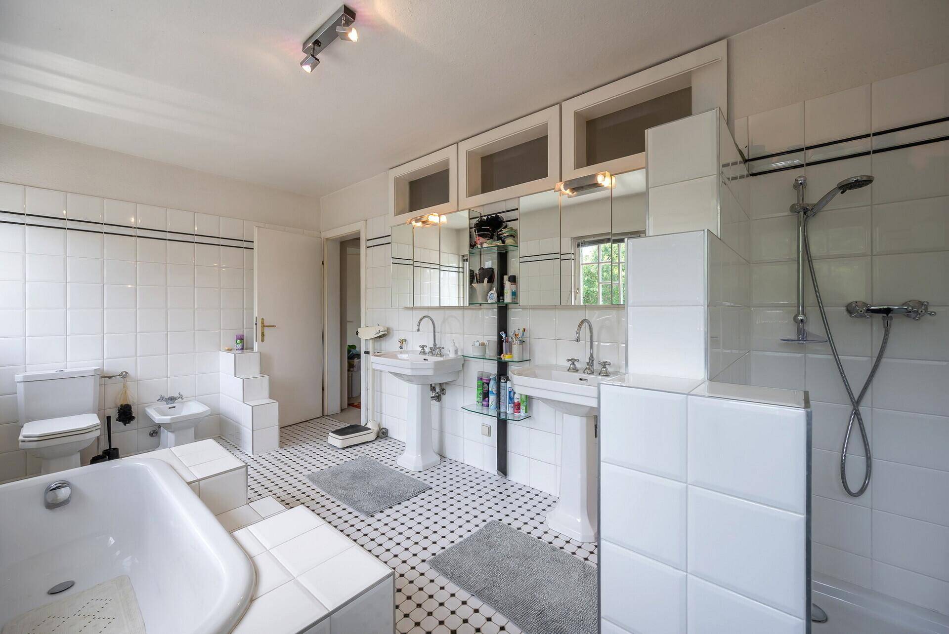 Großes Badezimmer mit zwei Waschbecken, Badewanne und separater Dusche.