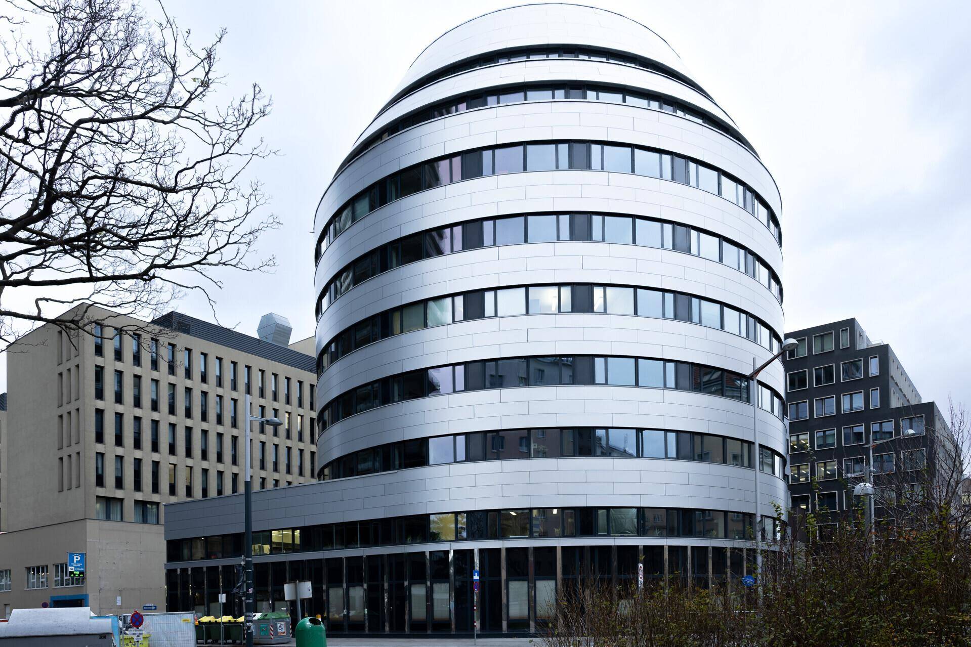 Auffälliges, modernes Gebäude mit geschwungener Fassade und vielen Fenstern in urbaner Umgebung.