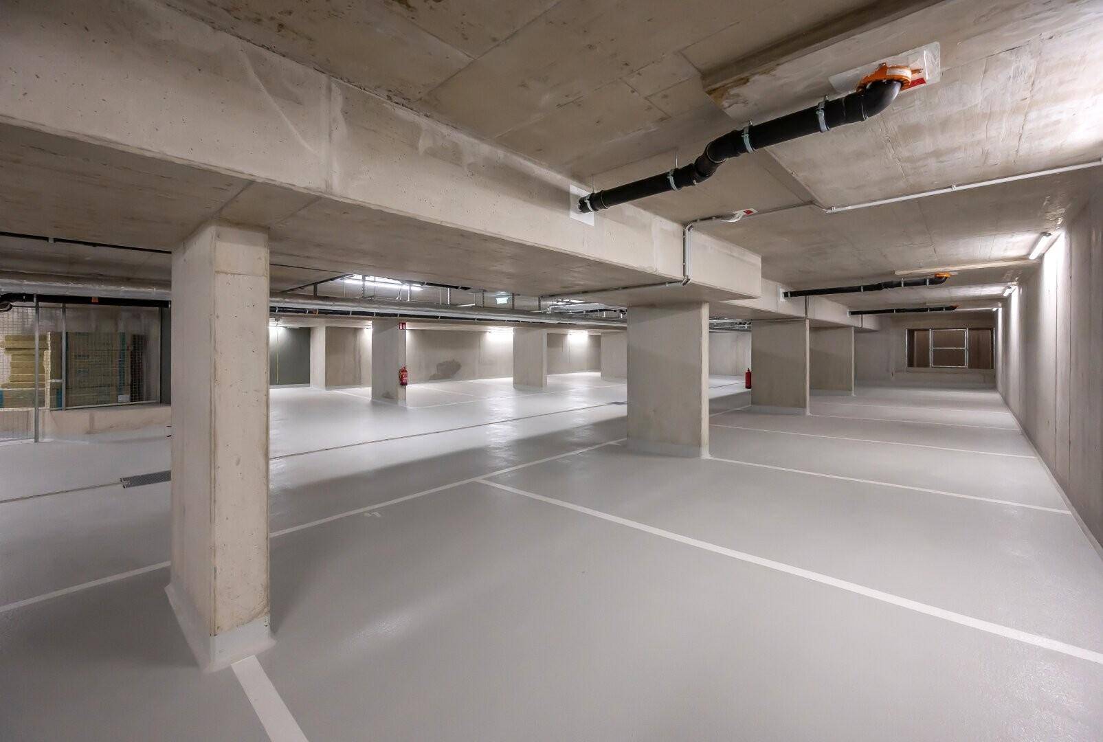 Geräumige Tiefgarage mit markierten Stellplätzen und Betonwänden.