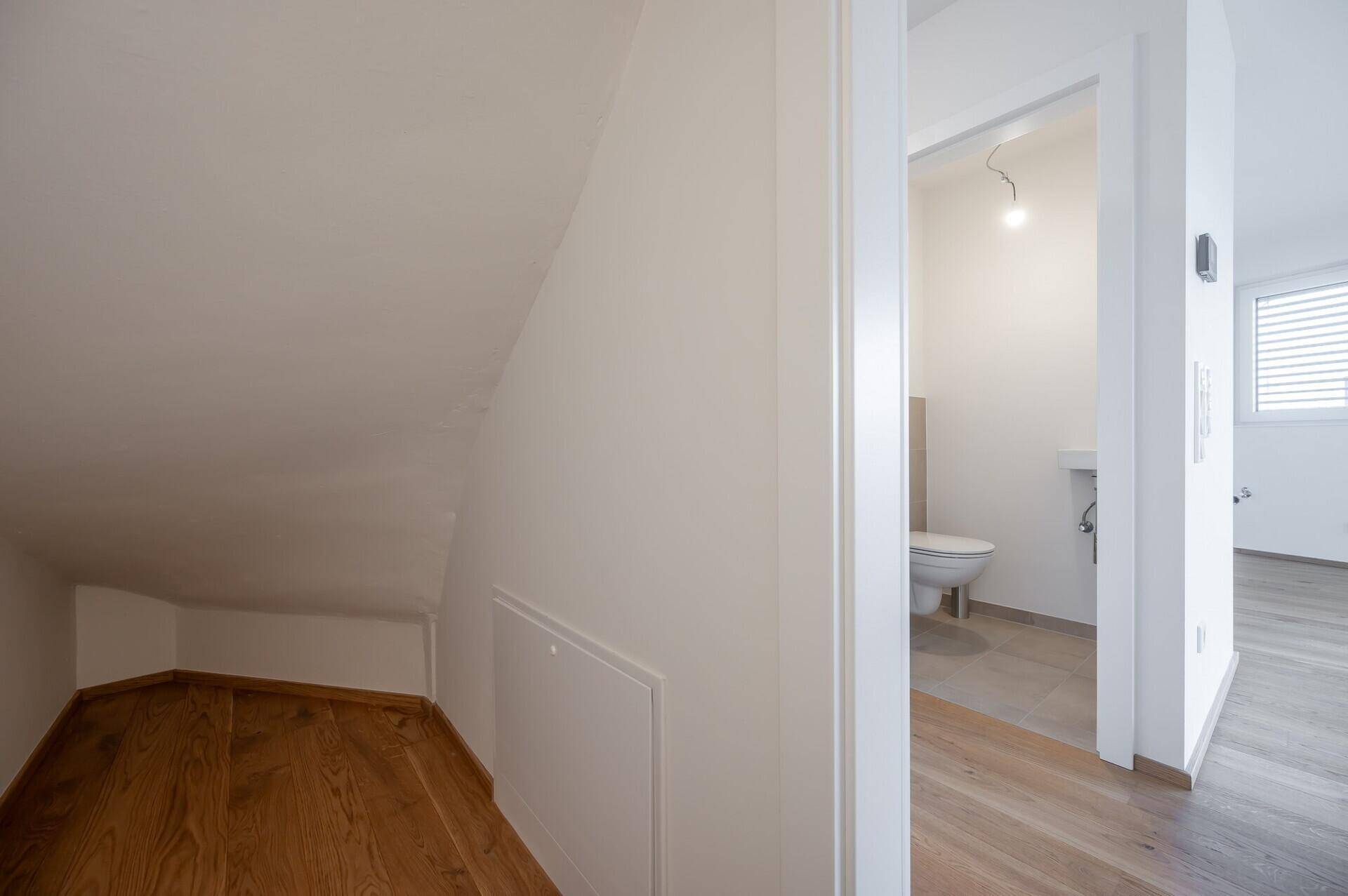 Praktischer Stauraum unter der Dachschräge mit Holzboden.