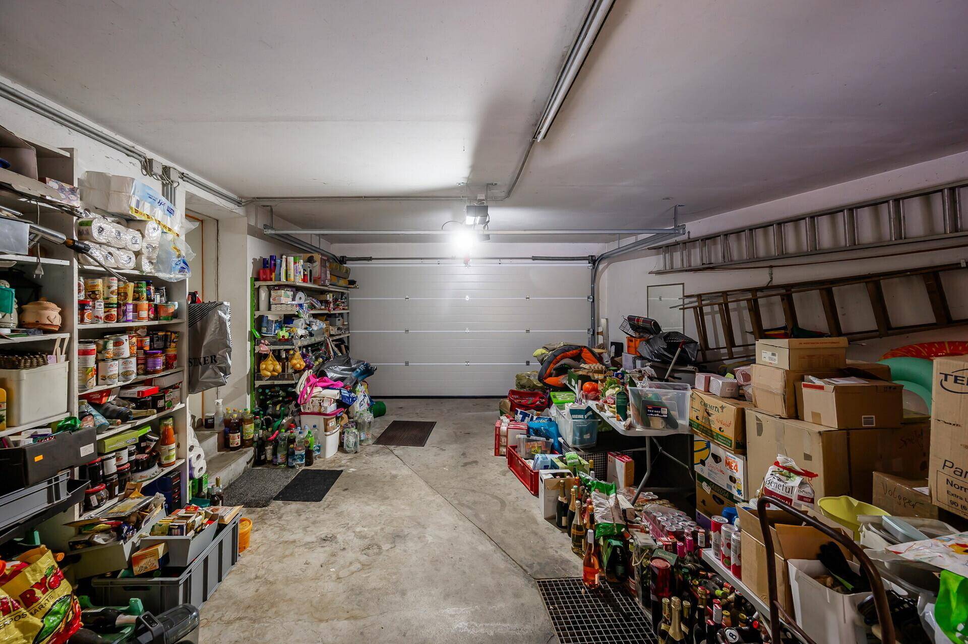 Geräumige Garage, die als Lagerraum mit vielen Regalen genutzt wird.