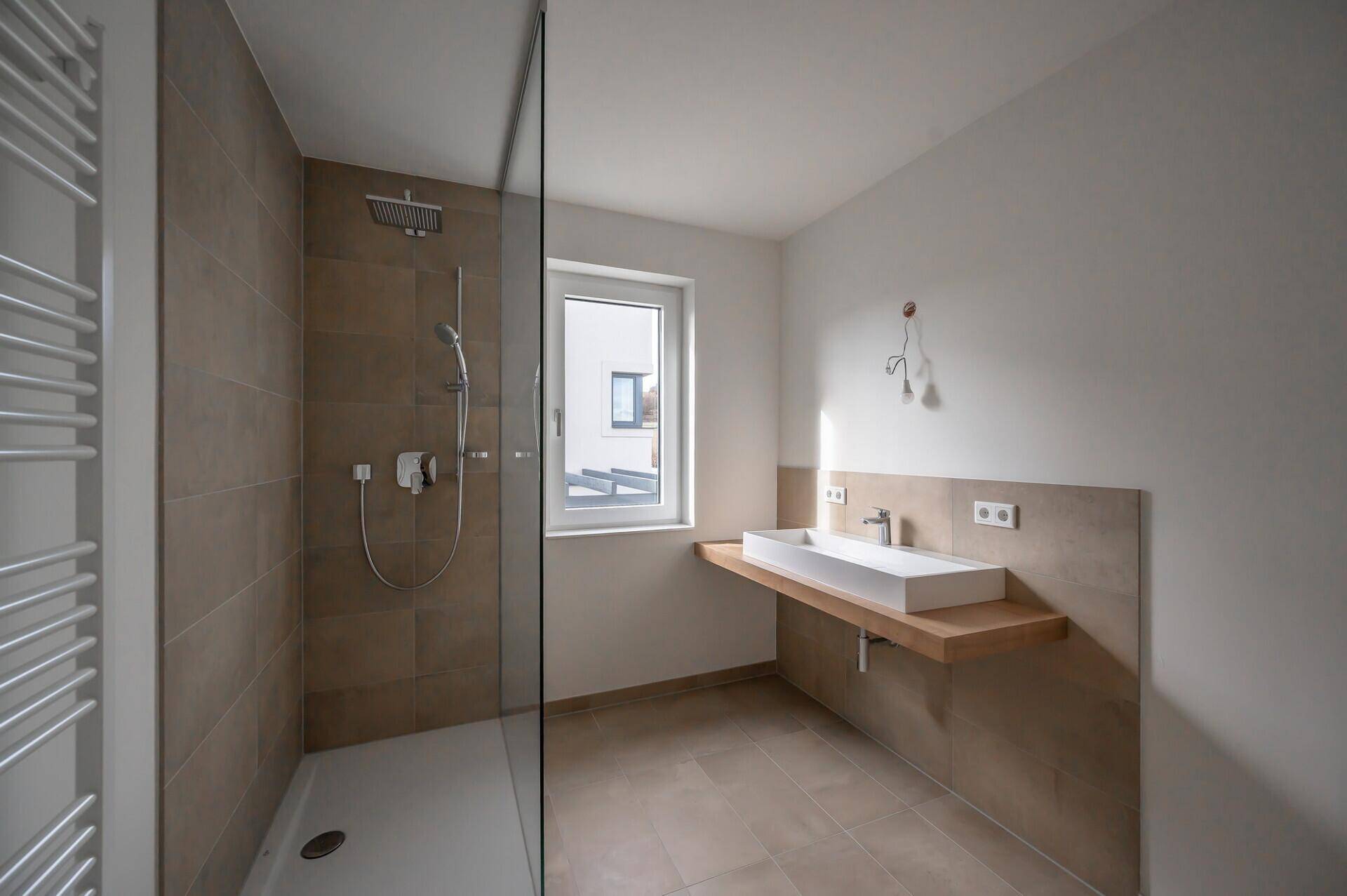Modernes Badezimmer mit ebenerdiger Dusche, Einzelwaschbecken und Fenster.