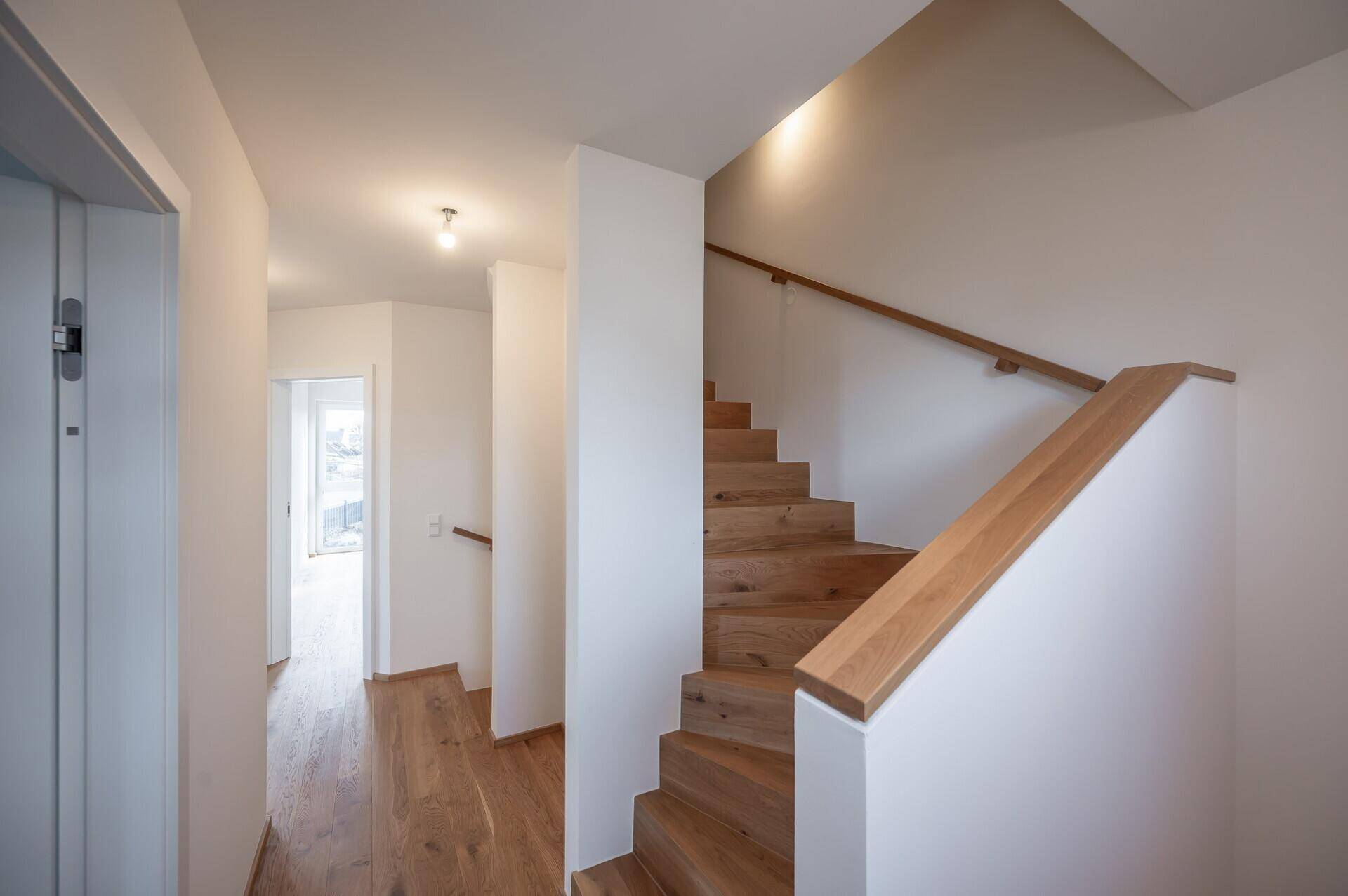 Heller Flur mit Holztreppe und Eichenparkett, der zu den oberen Etagen führt.