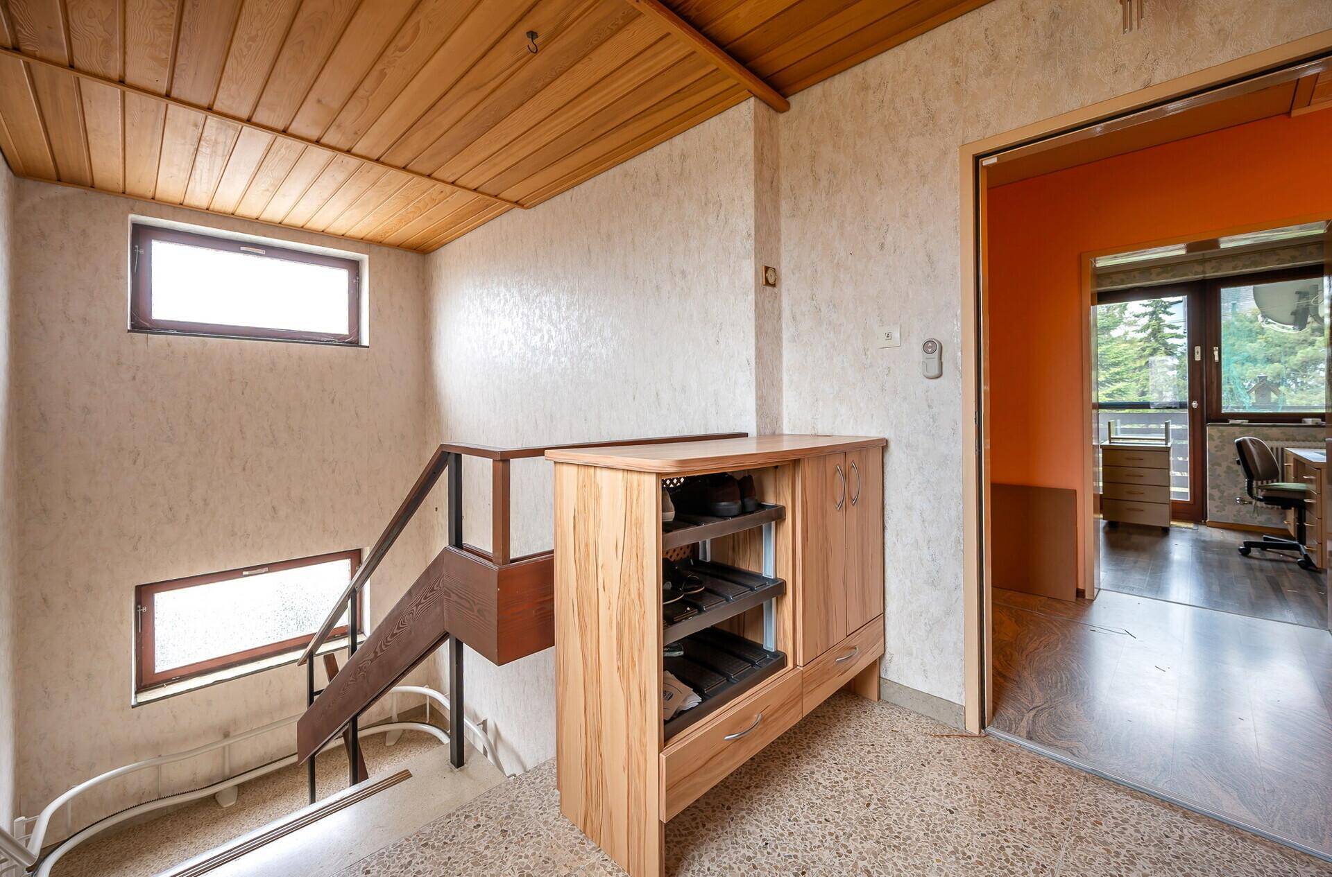 Flur mit Holzdecke, Schuhschrank und Zugang zu weiteren Räumen im Haus.