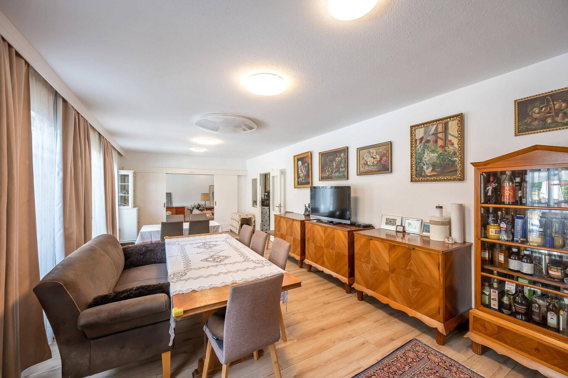 Heller Essbereich mit großem Esstisch, Holzmöbeln und Zugang zur Terrasse.