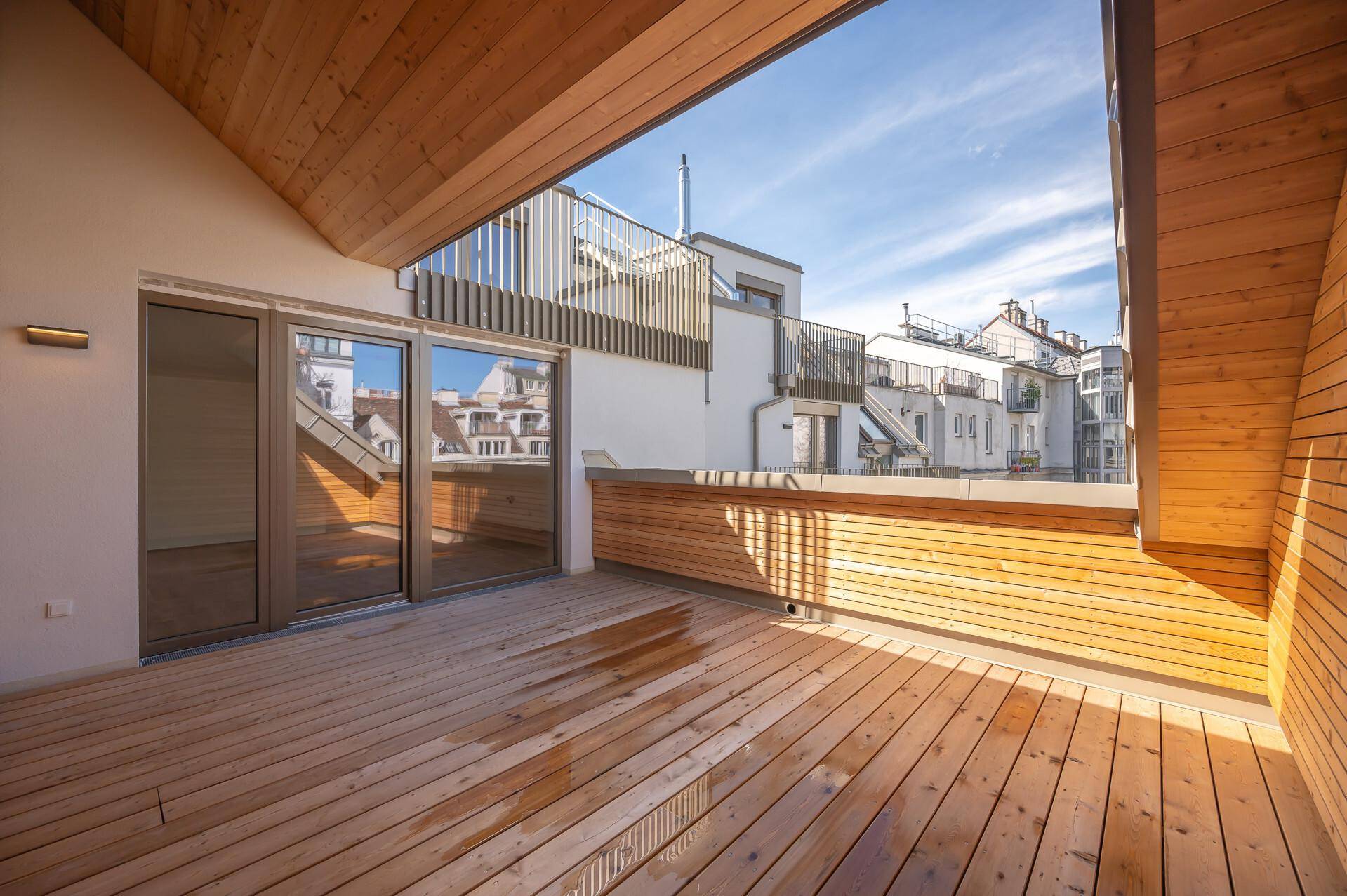 Große Dachterrasse mit Holzboden und Holzverkleidung, bietet viel Platz im Freien.