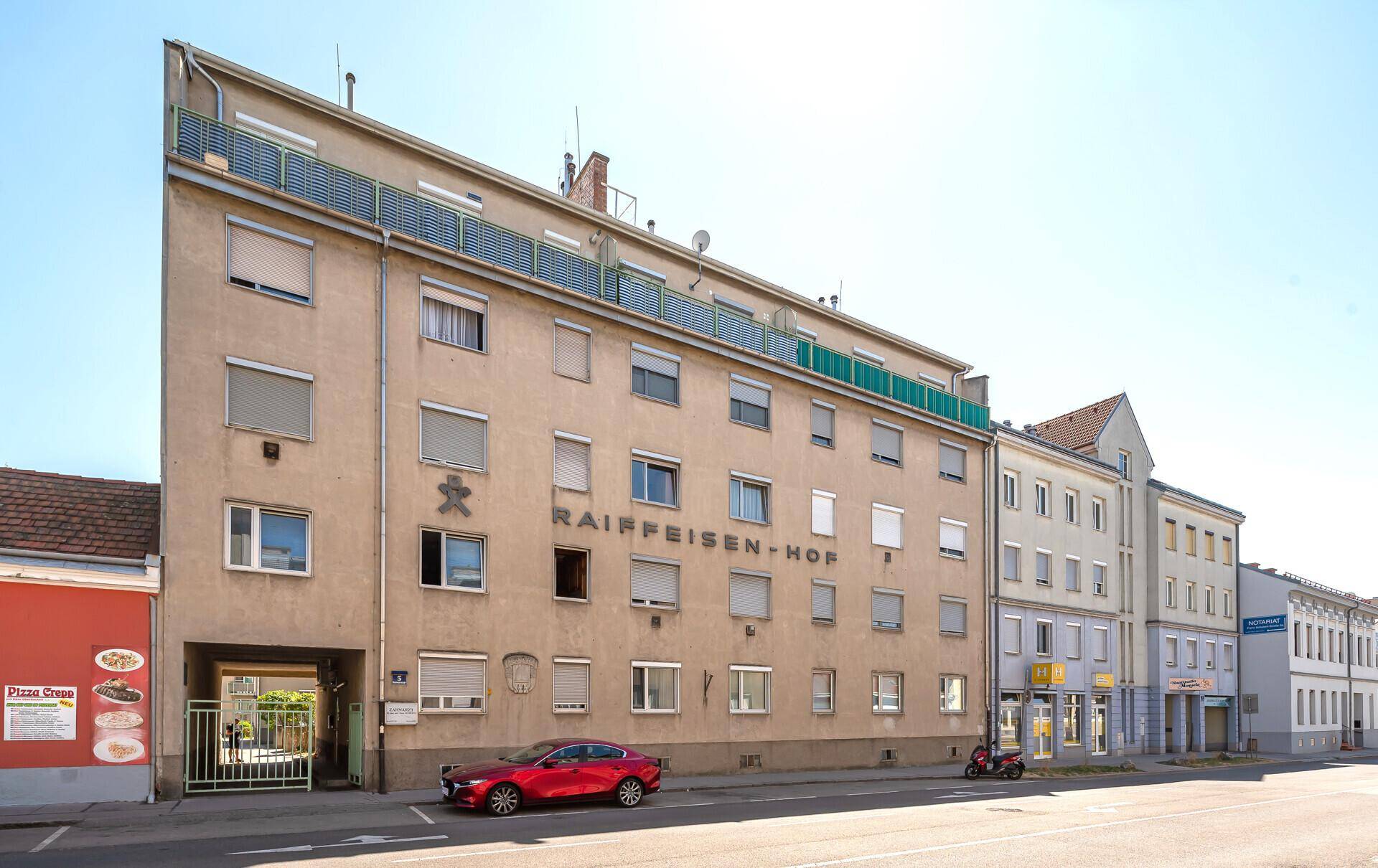 Straßenansicht eines Wohn- und Geschäftshauses mit gepflegter Fassade.