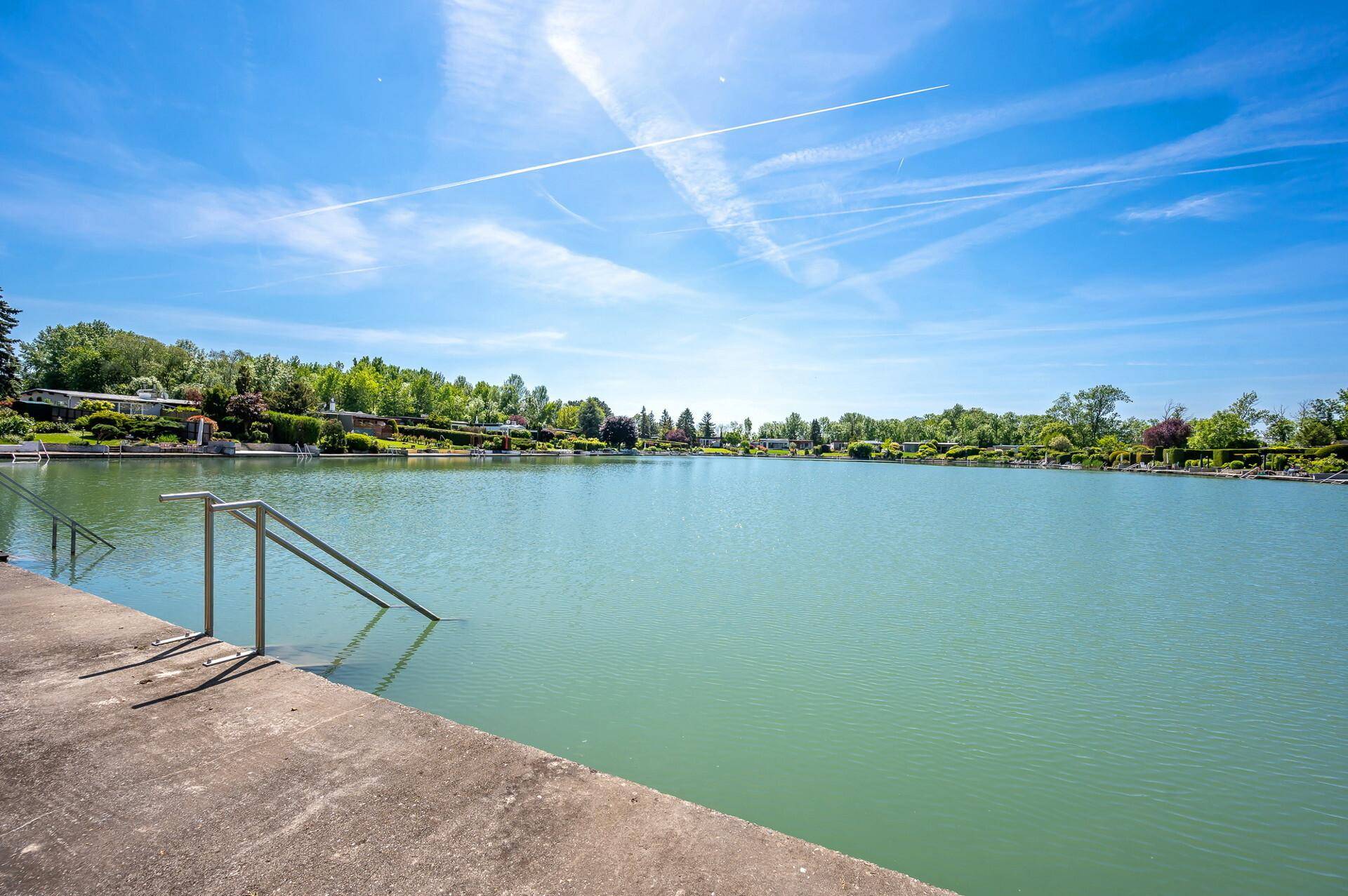 Direkter Seezugang über einen Betonsteg an einem sonnigen Tag mit weitem Blick.