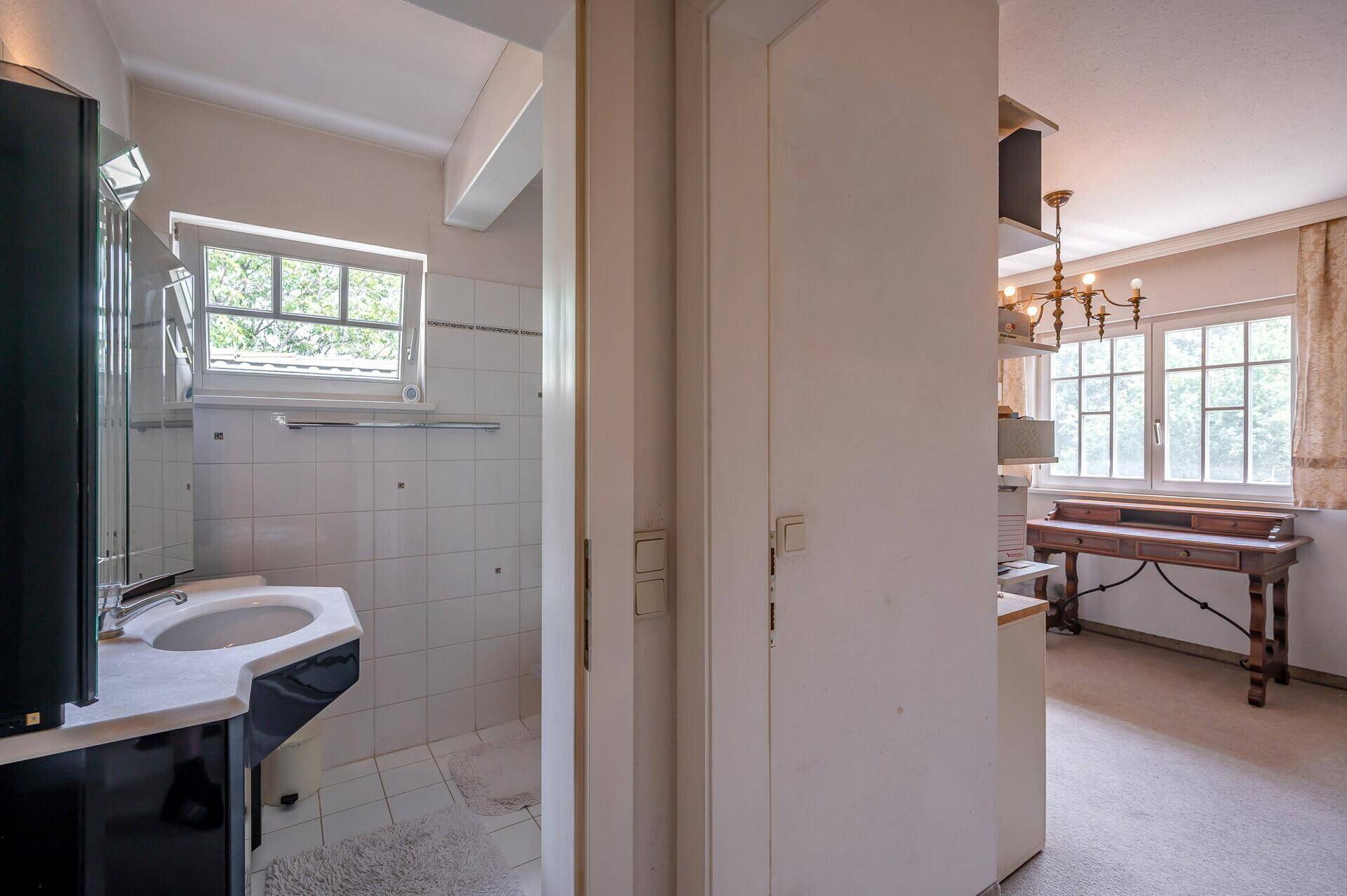 Flur mit Zugang zu einem Badezimmer und einem weiteren Zimmer.